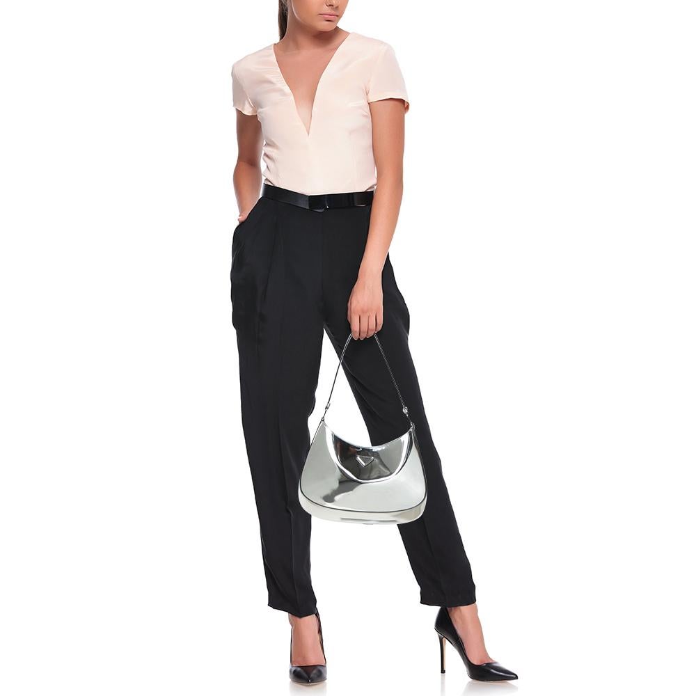 Die Cleo-Tasche von Prada wird in Italien aus Spiegelleder gefertigt und hat eine raffinierte Silhouette mit klaren Kurven. Das minimalistische:: silberfarbene Design wird durch eine Logoplakette akzentuiert und mit der polierten:: silberfarbenen