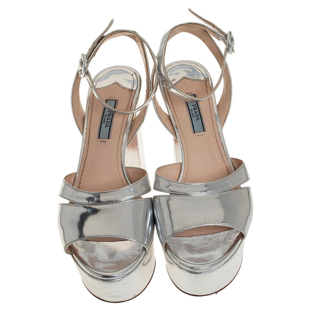 These sandals from Prada are a perfect blend of fashion and comfort! These silver-hued sandals are crafted from patent leather and feature an open-toe silhouette. They come equipped with leather-lined insoles, ankle straps, 10.5 cm block heels, and