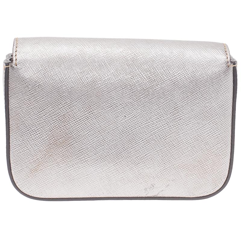 Grab this feminine and fun Mini Box clutch by Prada before it's too late! It is crafted from silver Saffiano leather and features gold Prada name sitting at the front flap. Secured with a snap button closure, the flap opens to a fabric lined