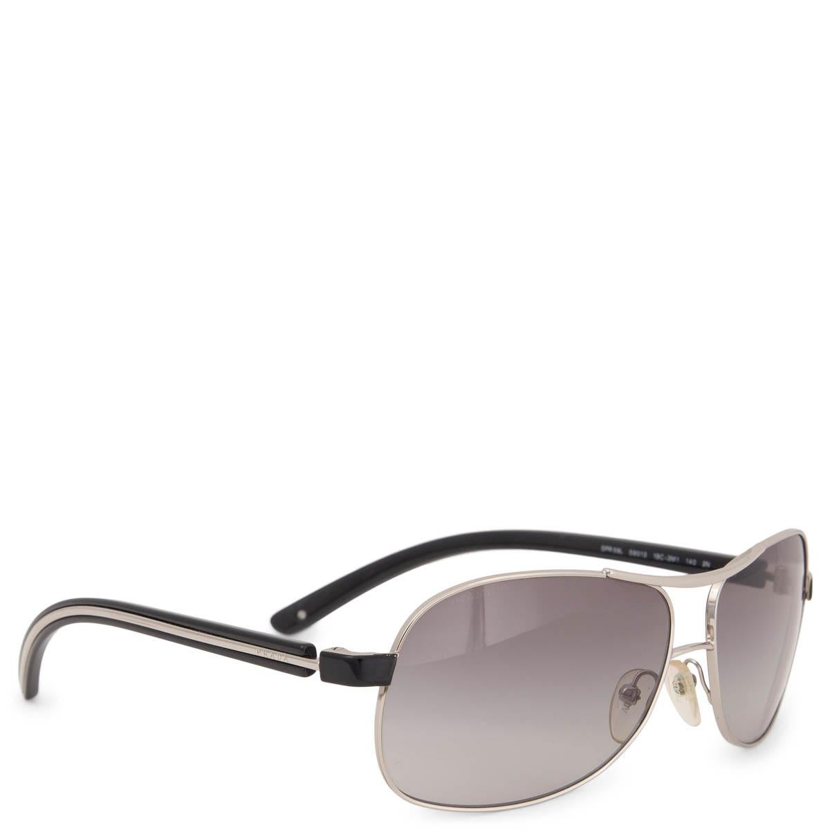 100% authentiques lunettes de soleil Prada SPR 59L composées d'une monture en métal de couleur argentée avec des verres dégradés gris clair et des branches en acétate noir. Ils ont été portés et sont en excellent état. Livré avec étui et boîte.