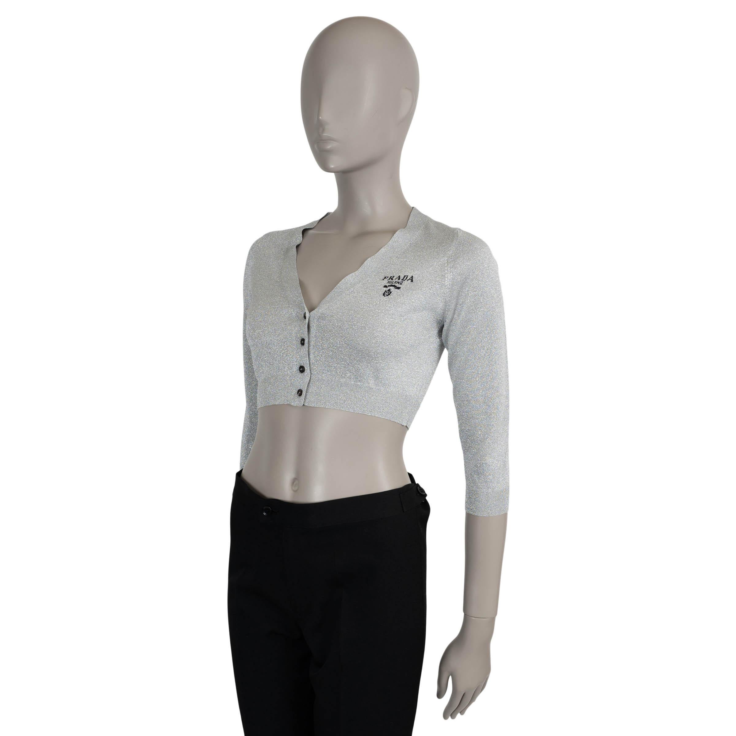 Diese 100% authentische Prada Strickjacke aus glitzernder, silberfarbener Lurex-Viskose (62%), Metallic-Faser (34%) und Polyester (4%) hat eine taillierte, verkürzte Silhouette mit V-Ausschnitt, Dreiviertel-Ärmeln und Rippstrickabschlüssen. Ein