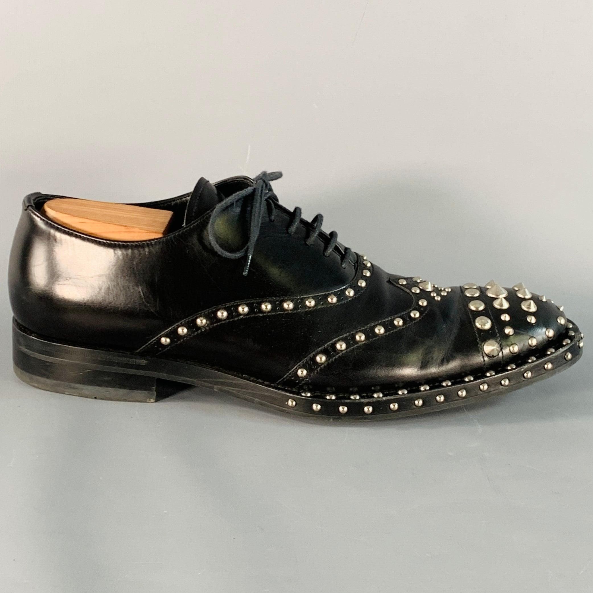PRADA oxford shoes
in a black leather featuring an all over silver tone metal studded design, cap toe, and lace-up closure. Shoe trees not included. Made in Italy.Very Good Pre-Owned Condition. Moderate creasing, minor signs of wear on metal.