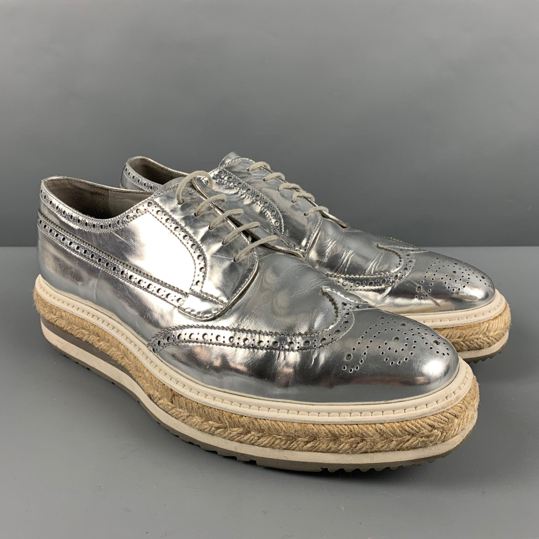 PRADA shoes
in a
metallic silver leather featuring a perforated style, platform sole with rattan detail, and lace-up closure. Made in Italy.Very Good Pre- Owned Condition. Minor signs of wear. 

Marked:   2EG015 9Outsole: 12.5 inches  x 4.25 inches