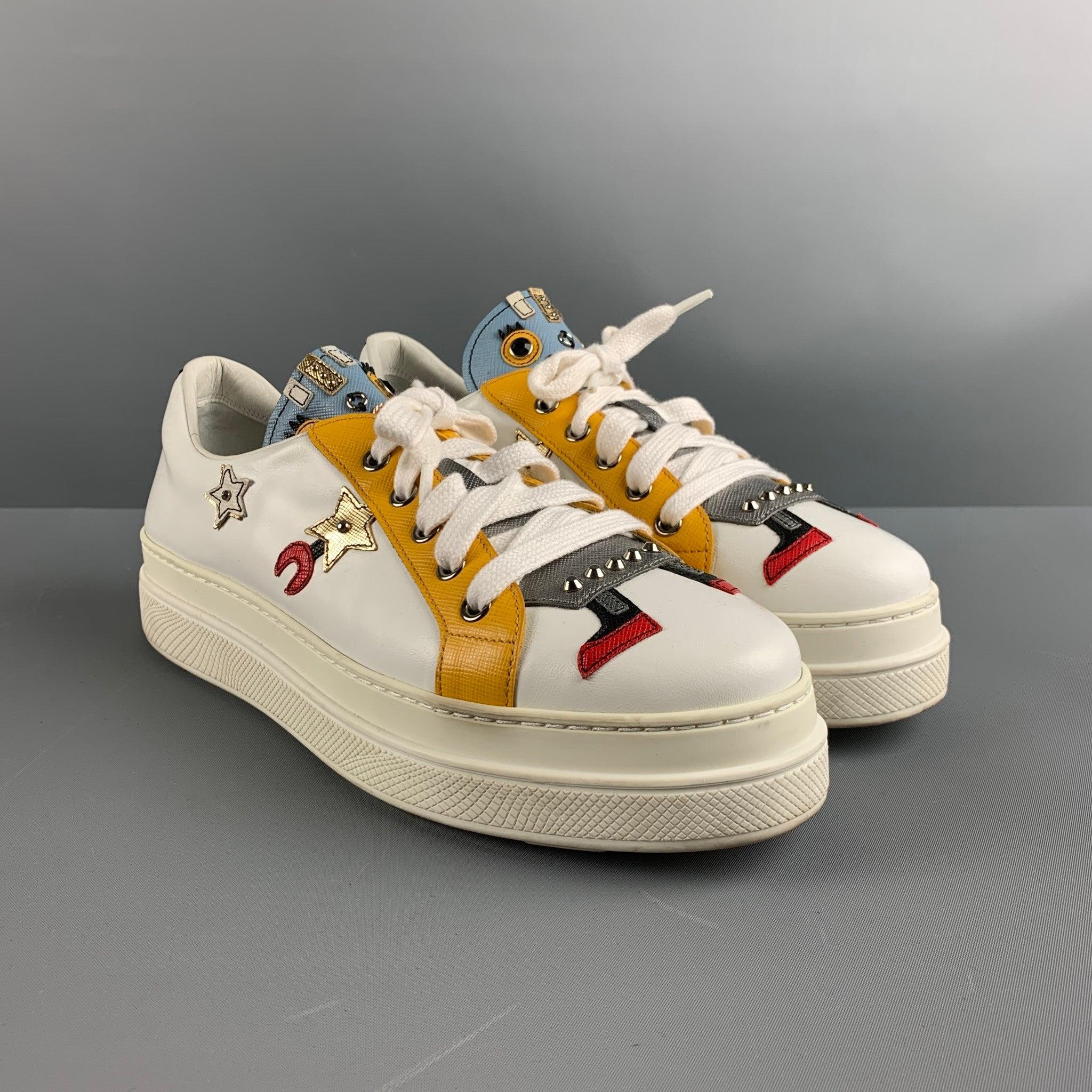 PRADA sneakers comes in a blue, yellow and white leather featuring a silver tone studded accents, robot motif, double rubber sole, and a slip on. Made in Italy.Very Good Pre- Owned Conditions. Minor signs of wear. 

Marked:   461 40Outsole: 11