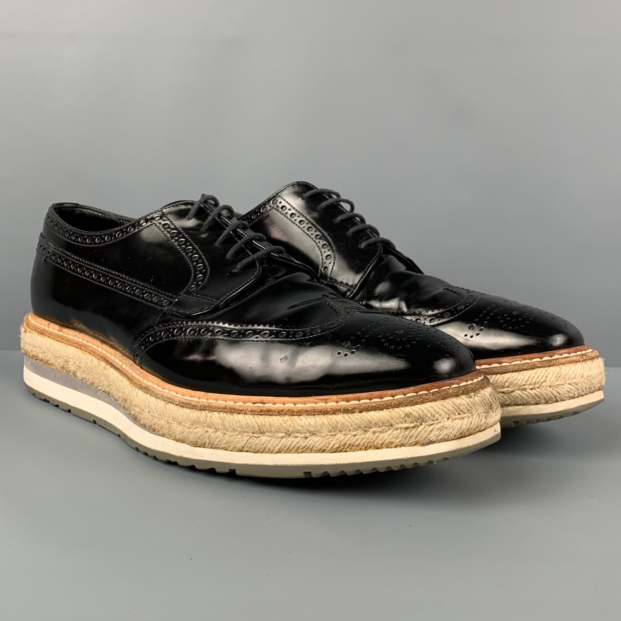 PRADA shoes comes in a black perforated leather featuring a wing tip style, jute trim rubber platform, square toe, and a lace up closure. Made in Italy.

Very Good Pre-Owned Condition. Light wear. As-Is.
Marked: 2EG015 9.5

Outsole: 13 in. x 4.25