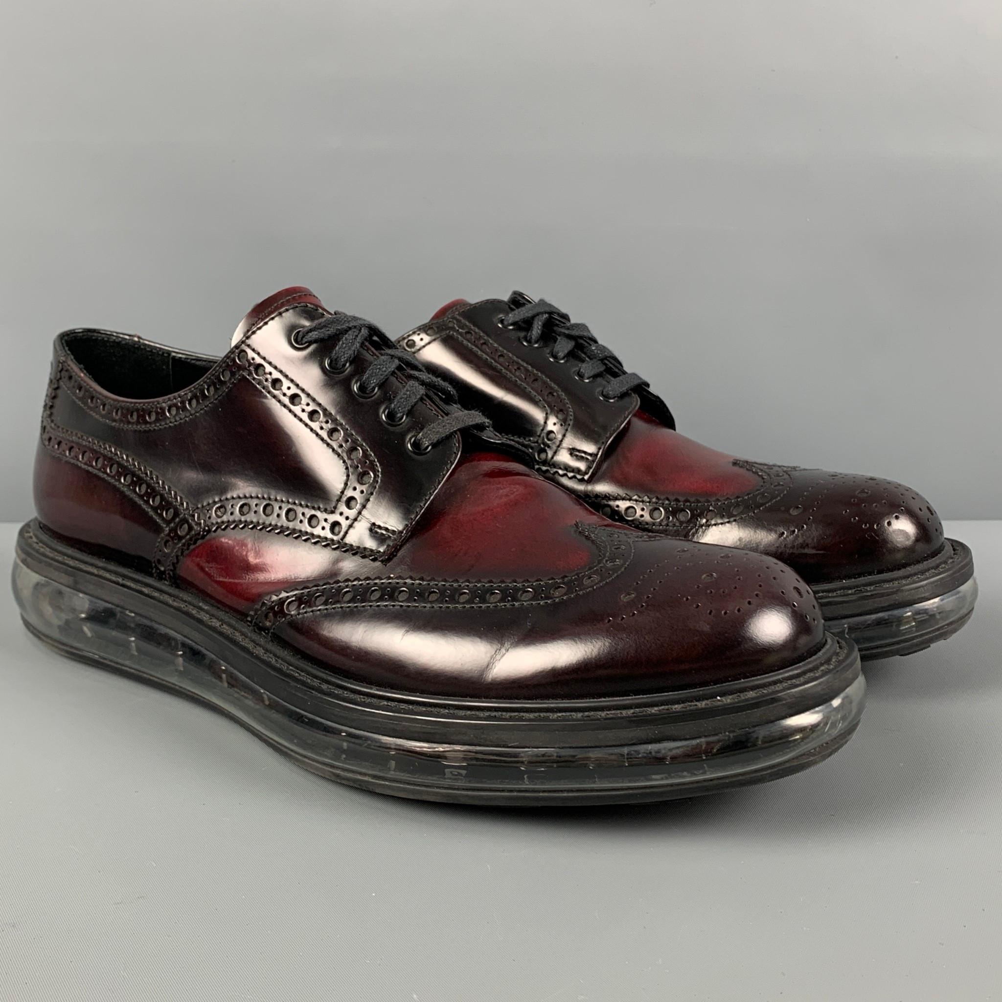 PRADA shoes comes in a burgundy perforated leather featuring a transparent rubber sole and a lace up closure. Made in Italy. 

Very Good Pre-Owned Condition.
Marked: 2EE098 9.5

Outsole: 13 in. x 4.5 in. 