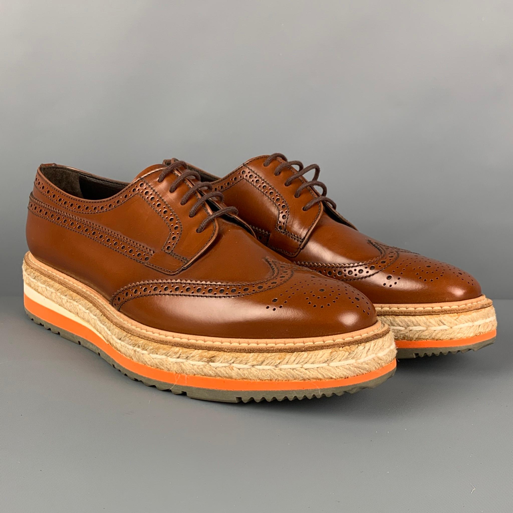 PRADA shoes comes in a tan perforated leather featuring a wingtip style, orange trim, jute trim platform sole, and a lace up closure. Made in Italy.

Very Good Pre-Owned Condition.
Marked: 40.5

Outsole: 11.5 in. x 4 in. 