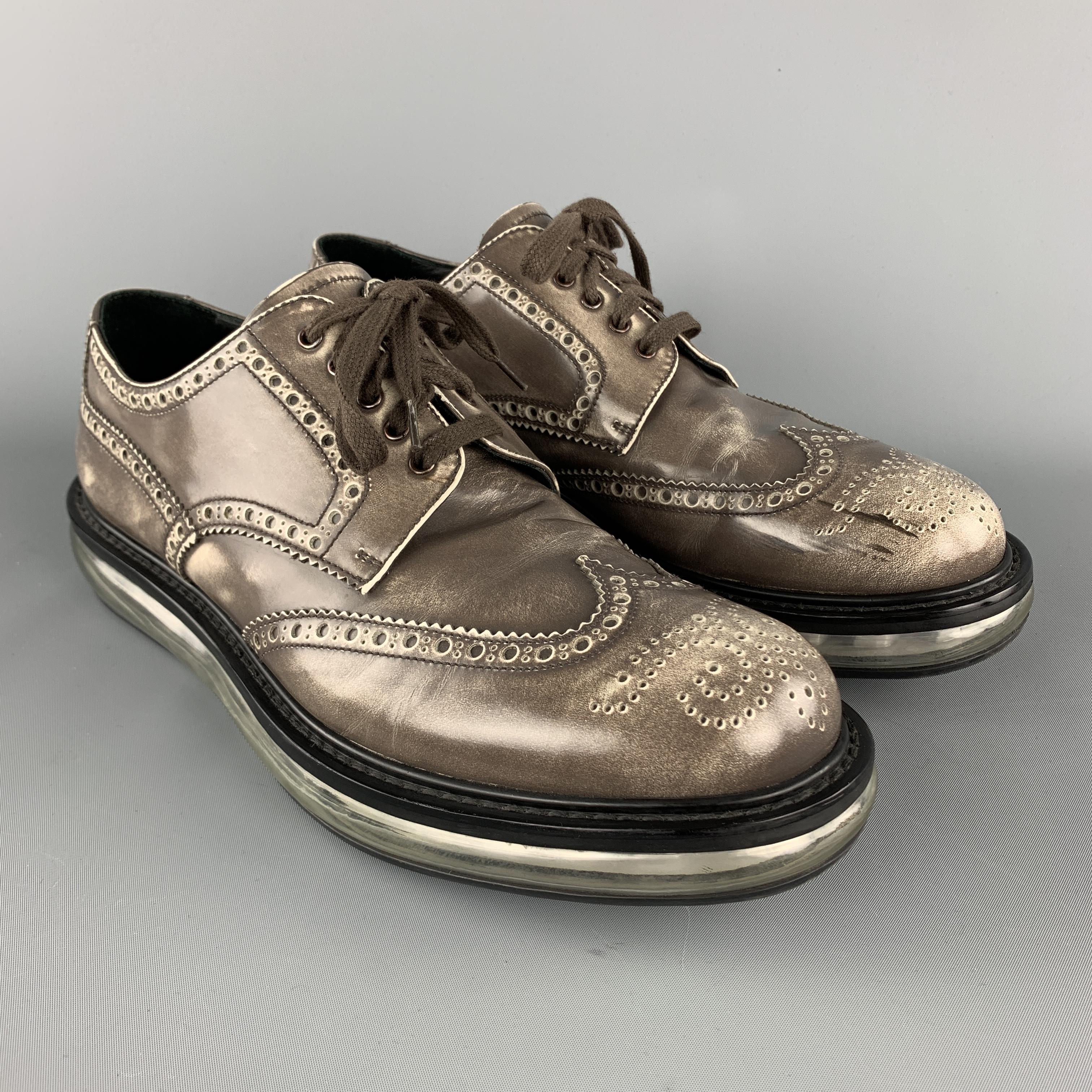 PRADA oxford lace up shoes comes in taupe and white tones in leather material, featuring an antique style, wingtip, a branded insole and a transparent sole. As is. Made in Italy.

Very Good Pre-Owned Condition.
Marked: UK 9.5  2EE 098 

Outsole: 13