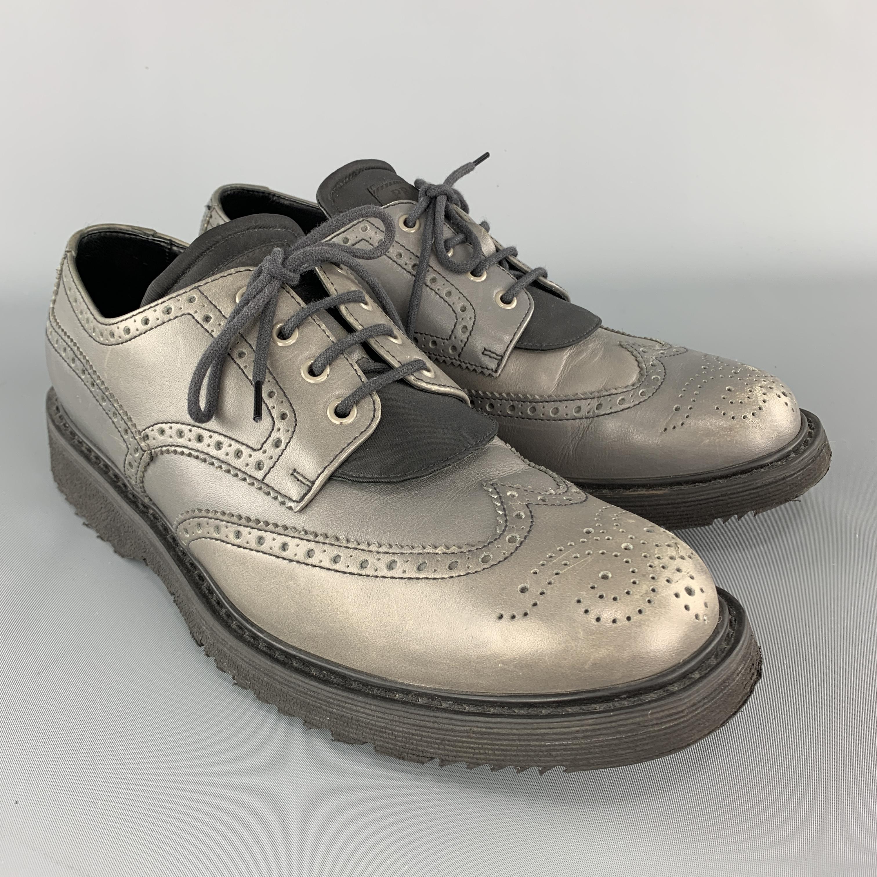 PRADA dress shoes come in gray leather with a medallion wingtip toe, nylon twill padded logo tongue, and rubber sole. Wear and discoloration throughout. As-is Made in Italy.

Fair Pre-Owned Condition.
Marked: UK 10

Outsole: 12.75 x 5 in.