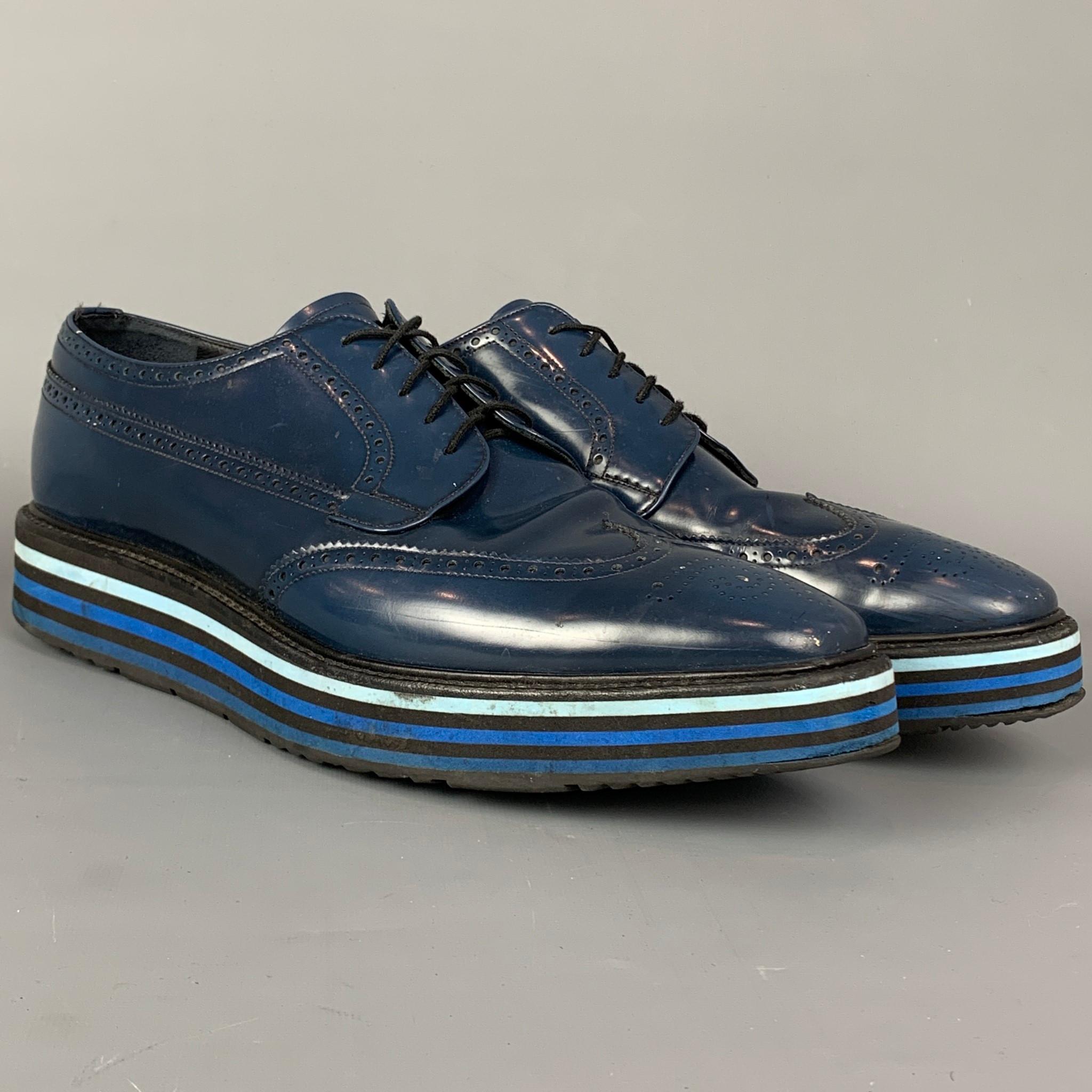 PRADA shoes comes in a blue perforated leather featuring a wingtip style, striped trim, platform, and a lace up closure. Comes with box.  Retail $980

Good Pre-Owned Condition. Moderate wear throughout.
Marked: 2EG015 12

Outsole:

13 in. x 4.5 in.