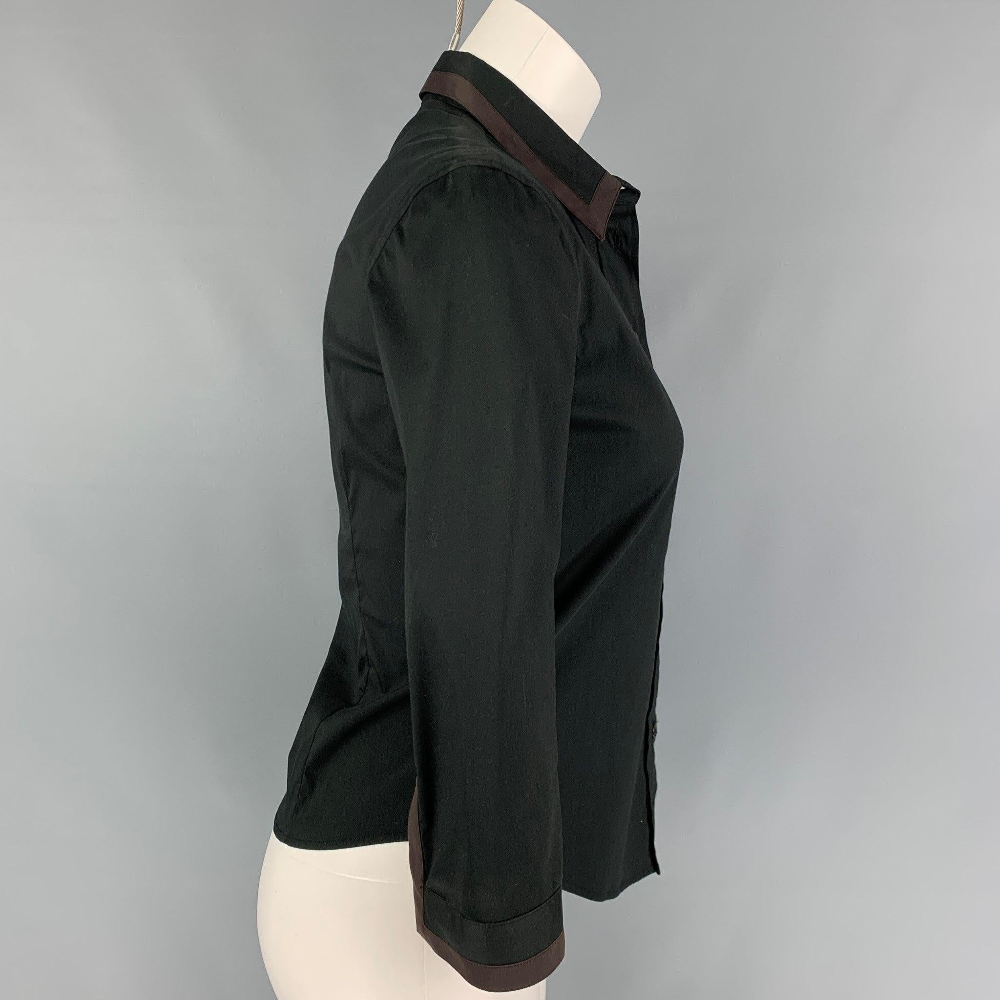 PRADA blouse comes in a black cotton / nylon featuring a brown trim, spread collar, and a buttoned closure. Made in Italy.
Very Good
Pre-Owned Condition. 

Marked:   38 

Measurements: 
 
Shoulder: 15.5 inches  Bust: 33 inches Sleeve: 17.75 inches 