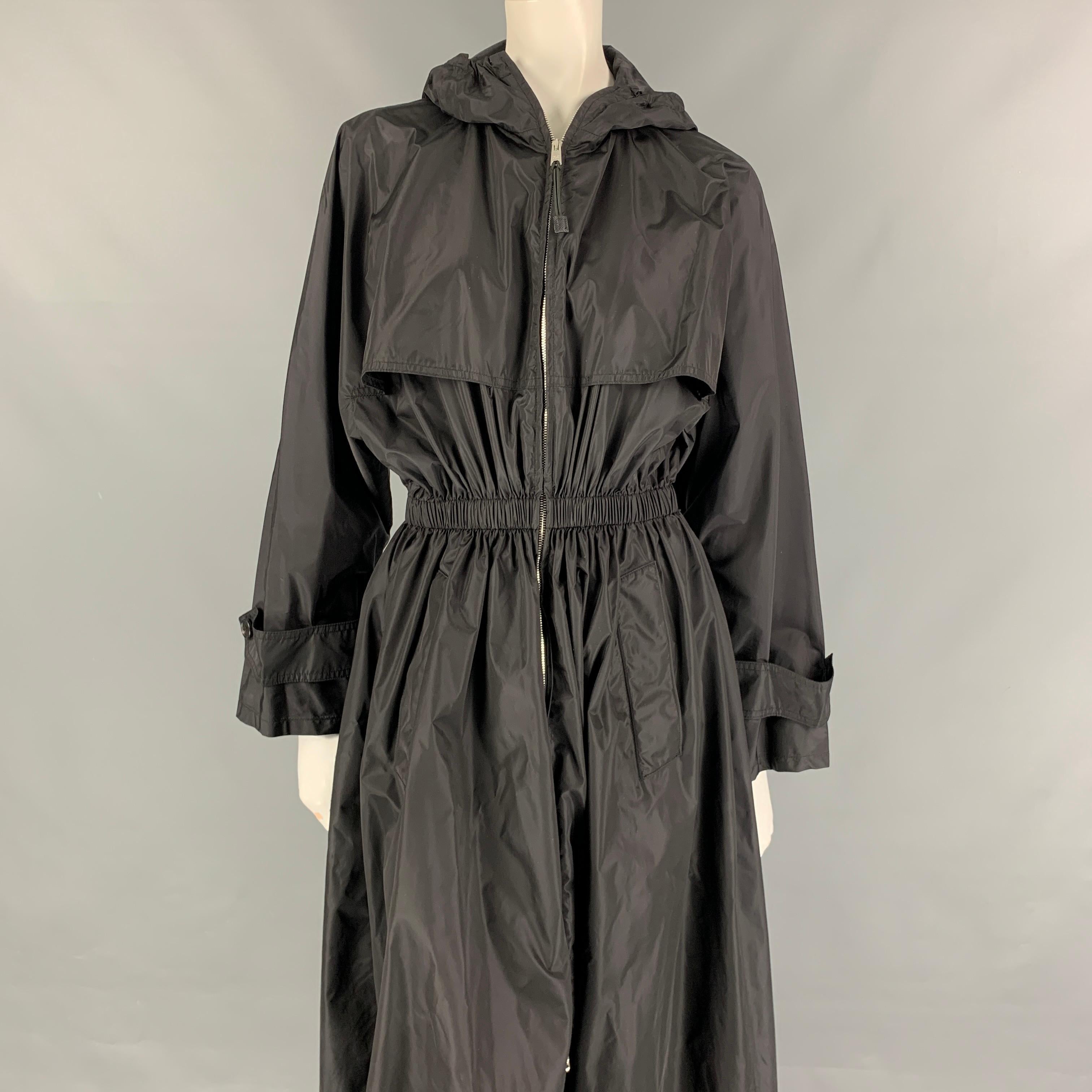 PRADA long coat comes in a black polyamide featuring a hooded style, elastic waistband, slit pockets, and a full zip up closure. Made in Italy. 

Very Good Pre-Owned Condition.
Marked: 38
Original Retail Price: $1,790.00

Measurements:

Shoulder: