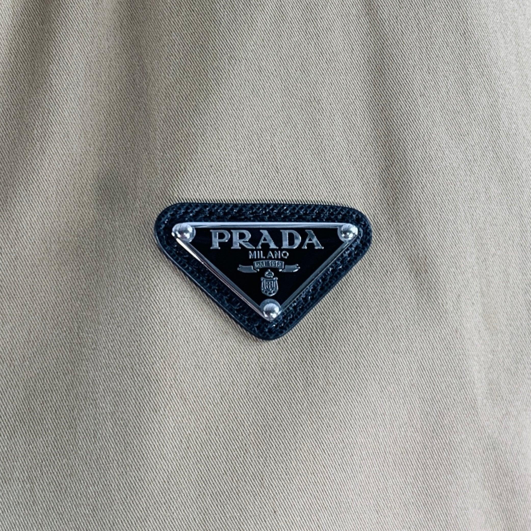 PRADA jacket
in a khaki cotton stretch blend fabric featuring a crop style, contrasting orange trim, hidden hood, and zip up closure. Made in Italy.Very Good Pre-Owned Condition. Minor marks. 

Marked:   IT 38 

Measurements: 
 
Shoulder: 23.5