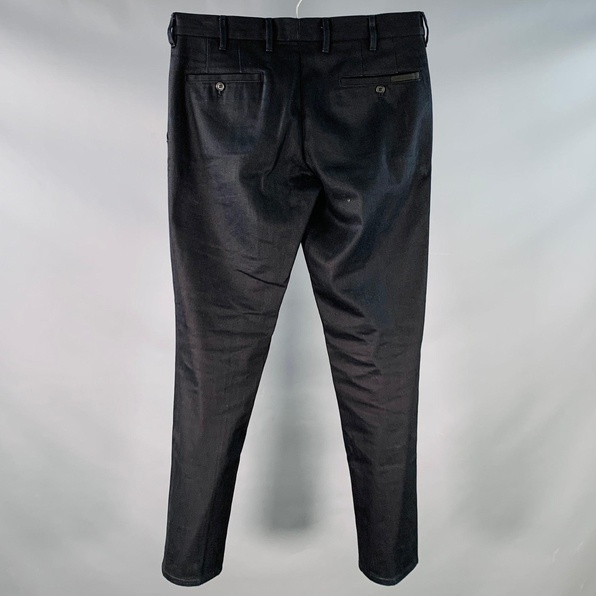 Pantalon décontracté PRADA
en sergé de coton tissé indigo noir surteint, avec un devant plat, une jambe fuselée et une braguette boutonnée. Fabriqué en Roumanie. Très bon état. Marques mineures. 

Marqué :   31 

Mesures : 
  Taille : 31 pouces