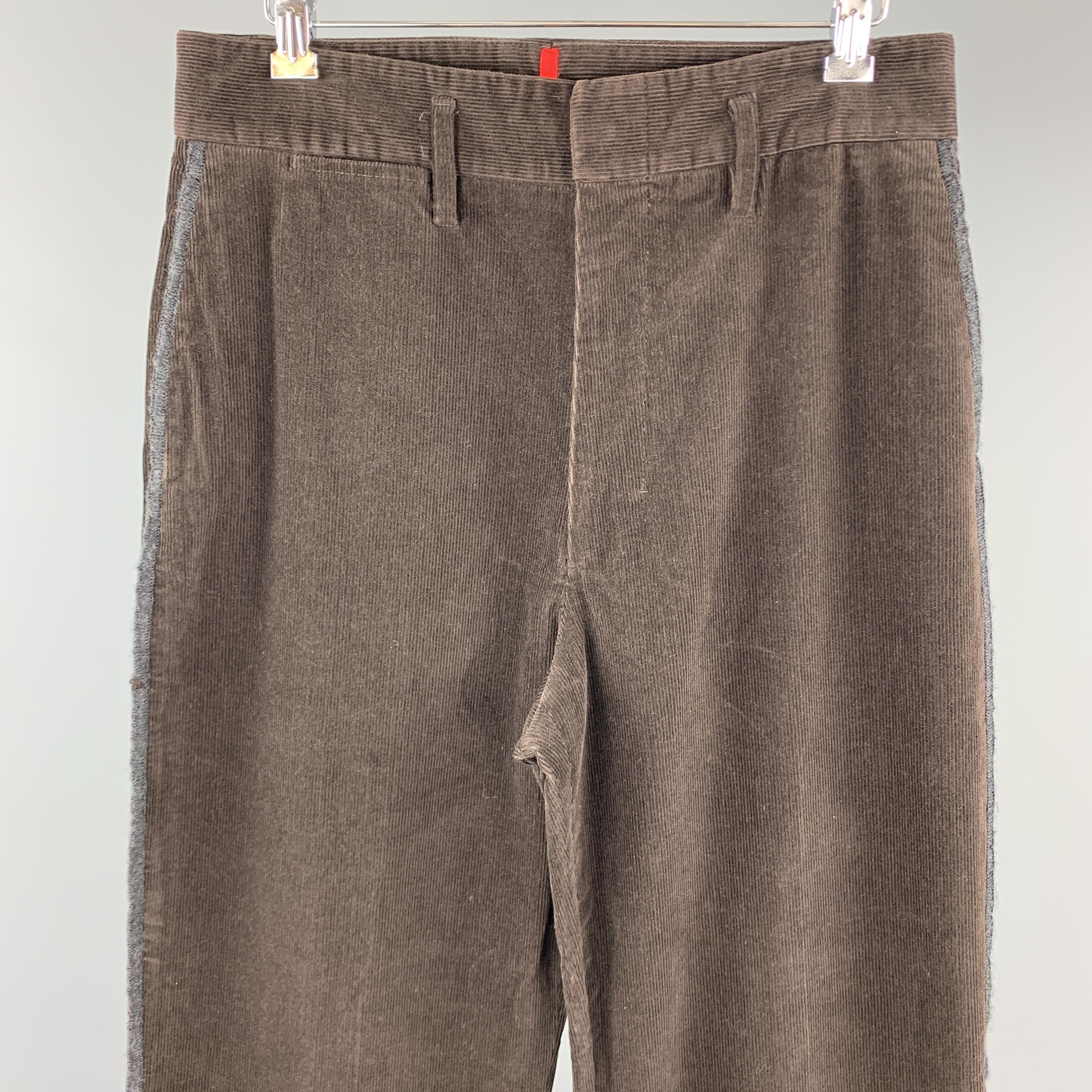 PRADA trousers come in dark brown corduroy with a high rise, hidden placket waistband, and side stripe. Made in Italy.

Good Pre-Owned Condition.
Marked: IT 48

Measurements:

Waist: 31 in.
Rise: 13 in.
Inseam: 28 in.