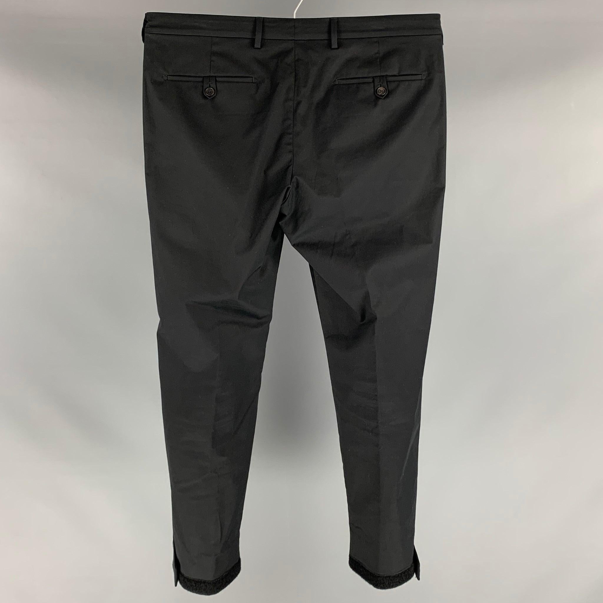 PRADA dress pants comes in black cotton and elastane material featuring a flat front, velcro cuffed leg, front tab, and a zip fly closure. Excellent Pre-Owned Condition. 

Marked:   50 

Measurements: 
  Waist: 36 inches Rise: 10 inches Inseam: 32