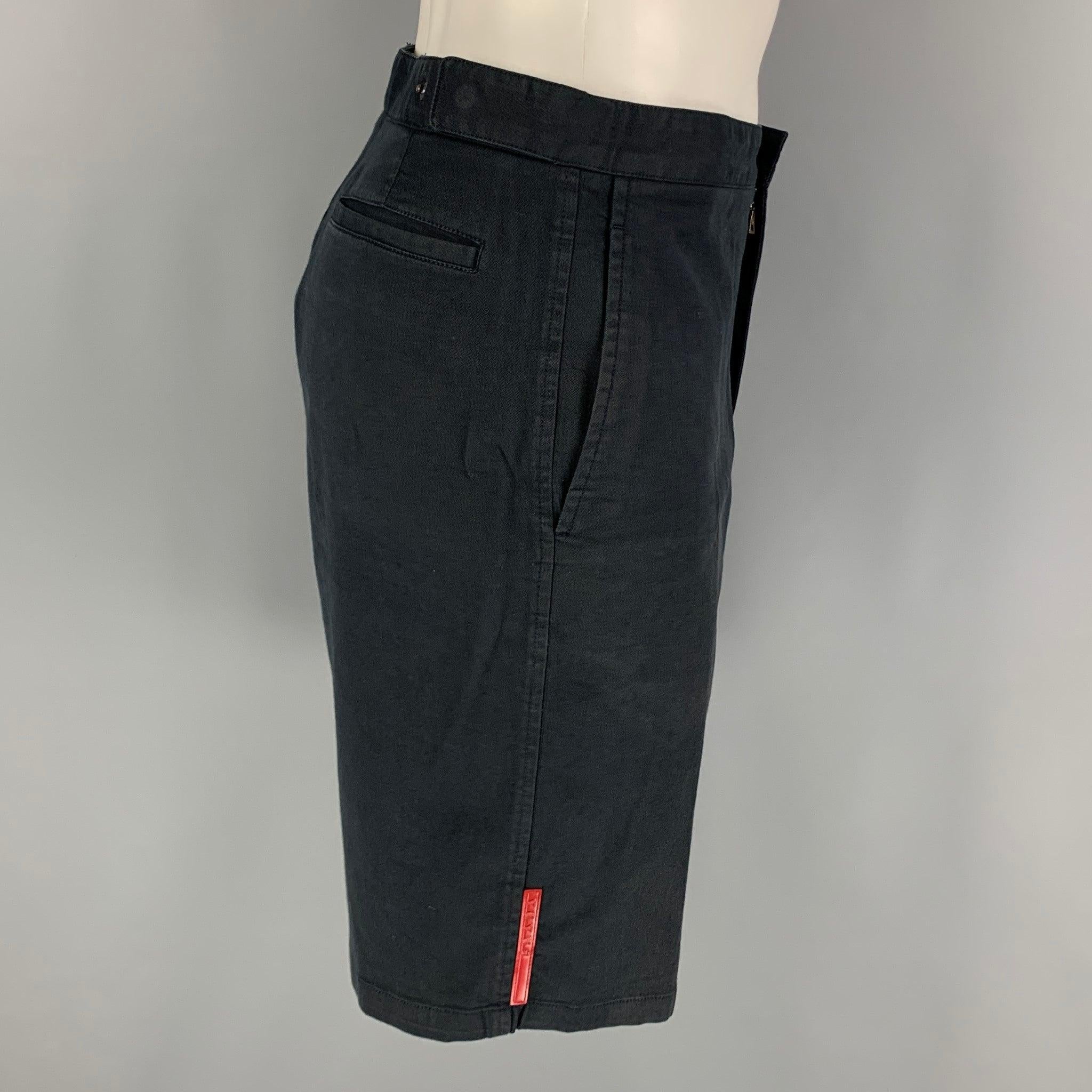 PRADA SPORT shorts comes in a navy cotton twill material with a side pockets, flat front, and zip up fly closure. Very Good Pre-Owned Condition. Moderate color fading. 

Marked:   50 

Measurements: 
  Waist: 32 inches Rise: 10 inches Inseam: 10.5