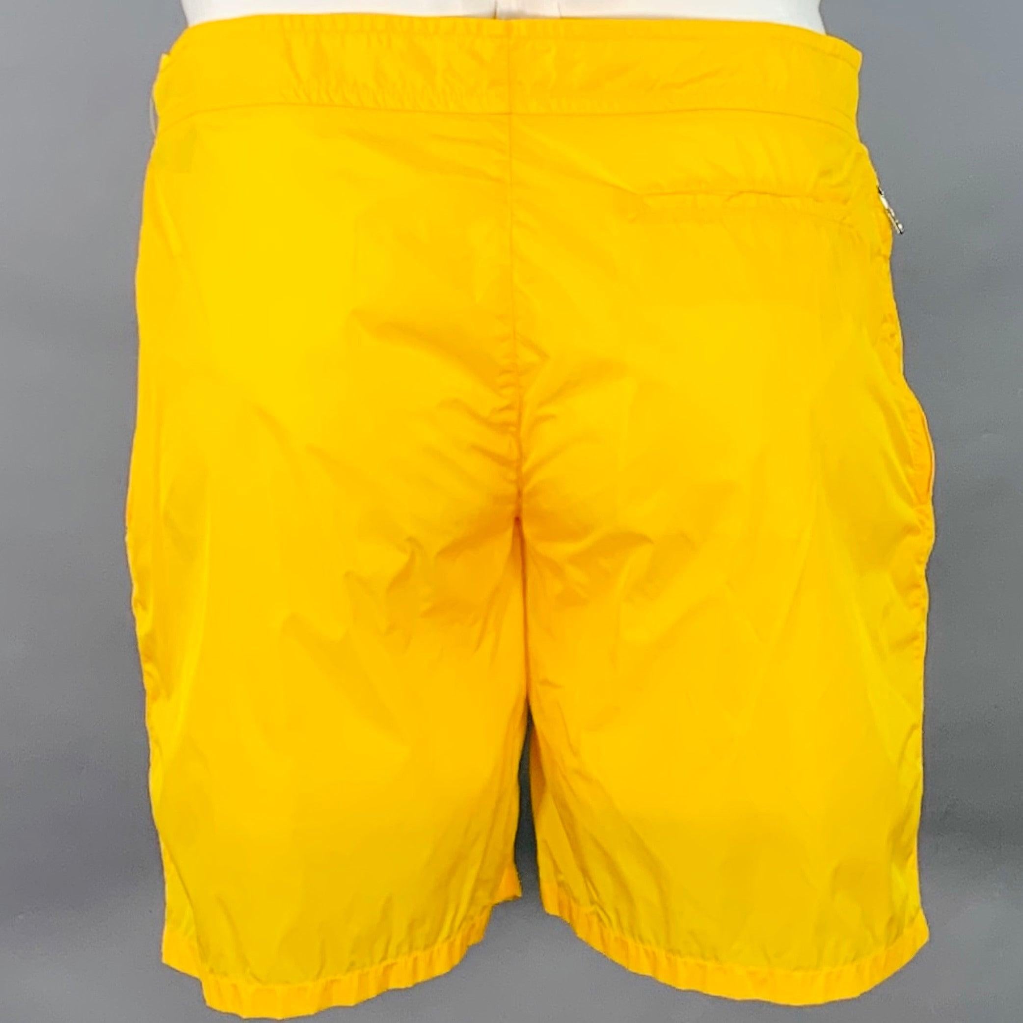 Pantaloncini da bagno Prada
in tessuto di nylon giallo con fodera in rete bianca, stile piatto e chiusura con zip. Made in Italy.Ottime condizioni di usato. Lievi segni di usura. 

Contrassegnato:   IT 50 

Misure: 
  Vita: 34 pollici Cavallo: 8,5