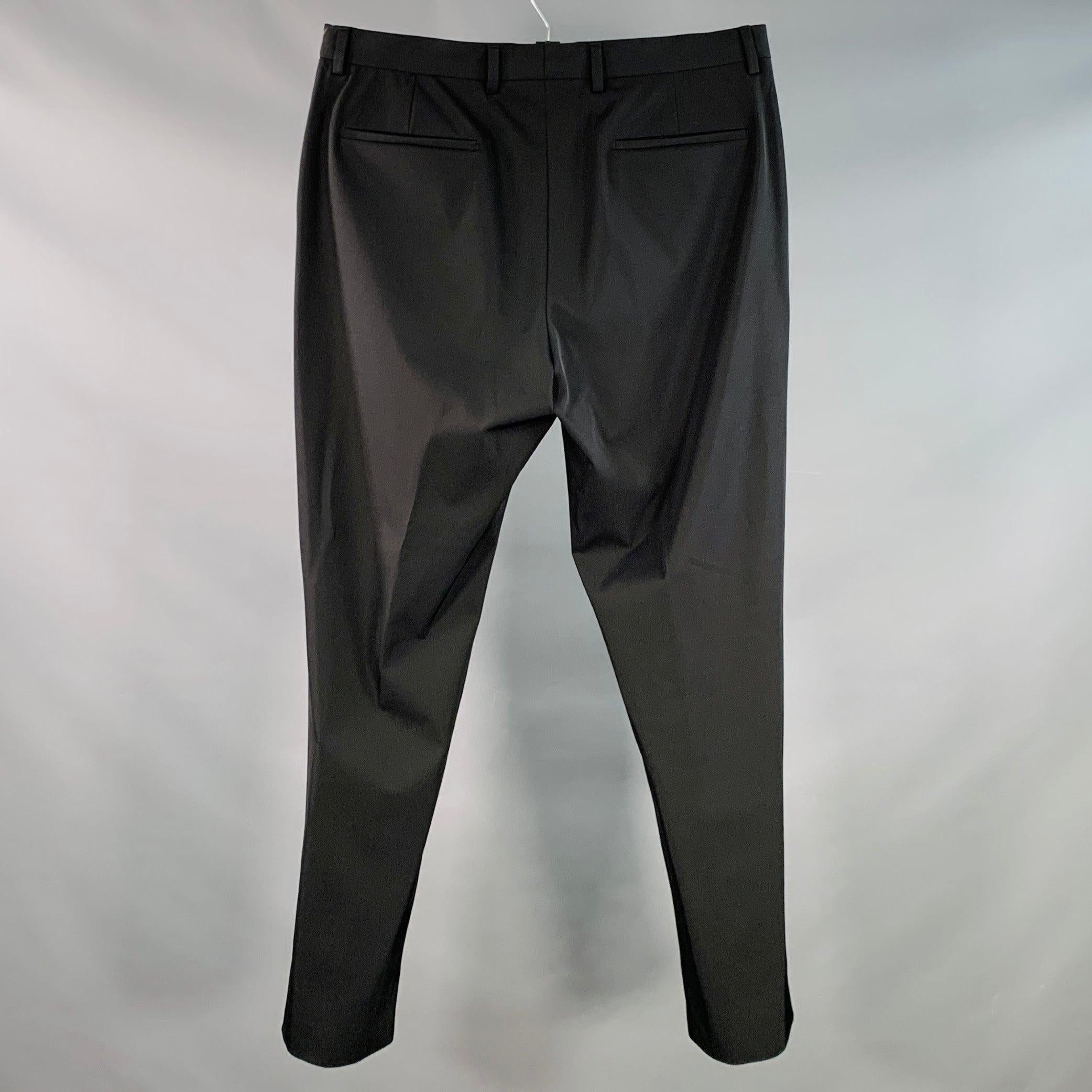 Pantaloni Prada
in tessuto misto poliestere elasticizzato nero, stile flat front, gamba affusolata e chiusura con bottoni. Made in Italy. Eccellente condizione di usato. 

Contrassegnato:   IT 52 

Misure: 
  Vita: 36 pollici Cavallo: 11 pollici