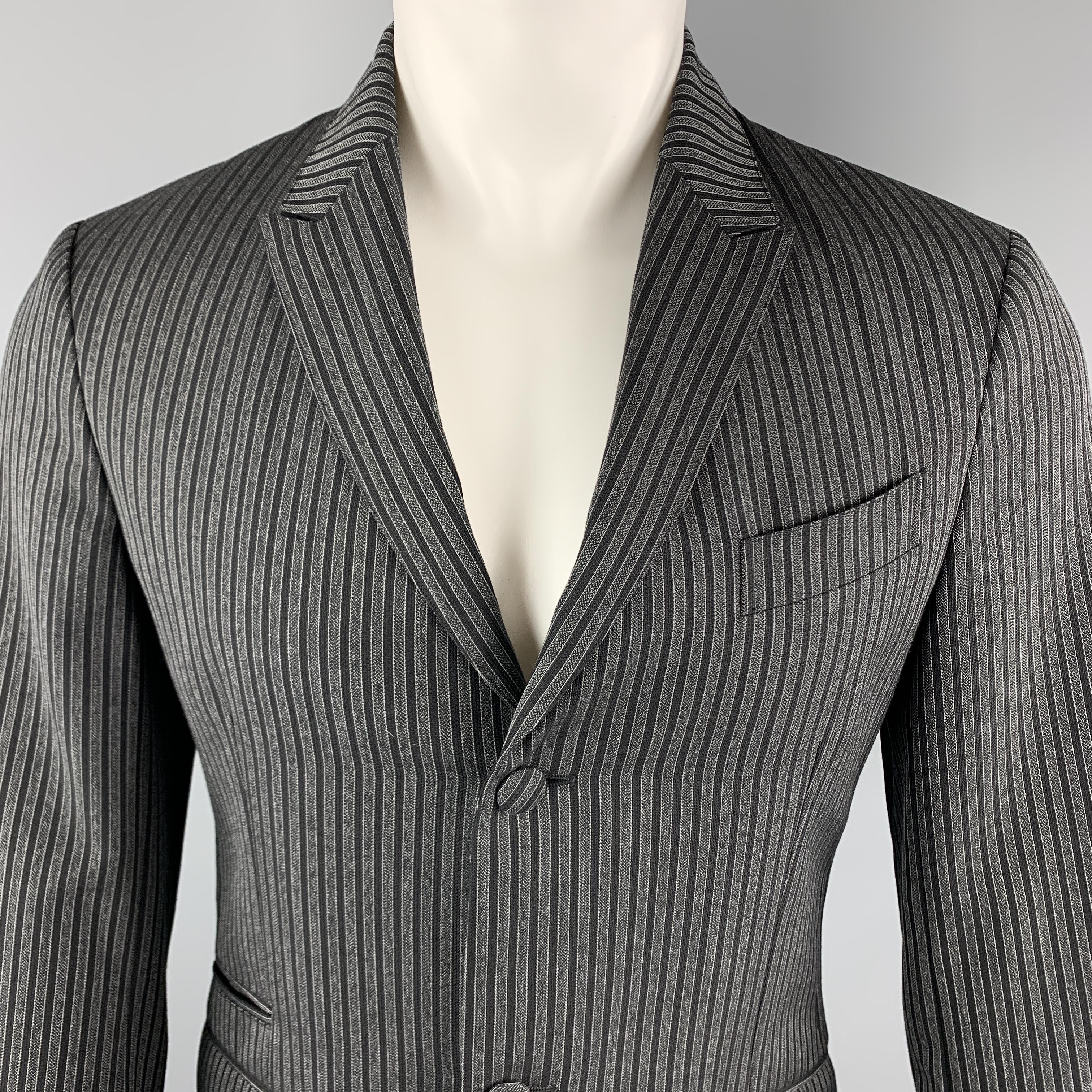 PRADA Sport Coat comes in charcoal and black vertical striped wool / mohair material, featuring a peak lapel, two buttons at closure, single breasted, slit and flap pockets, buttoned cuffs, and a single vent at back. Made in Italy. 

Excellent