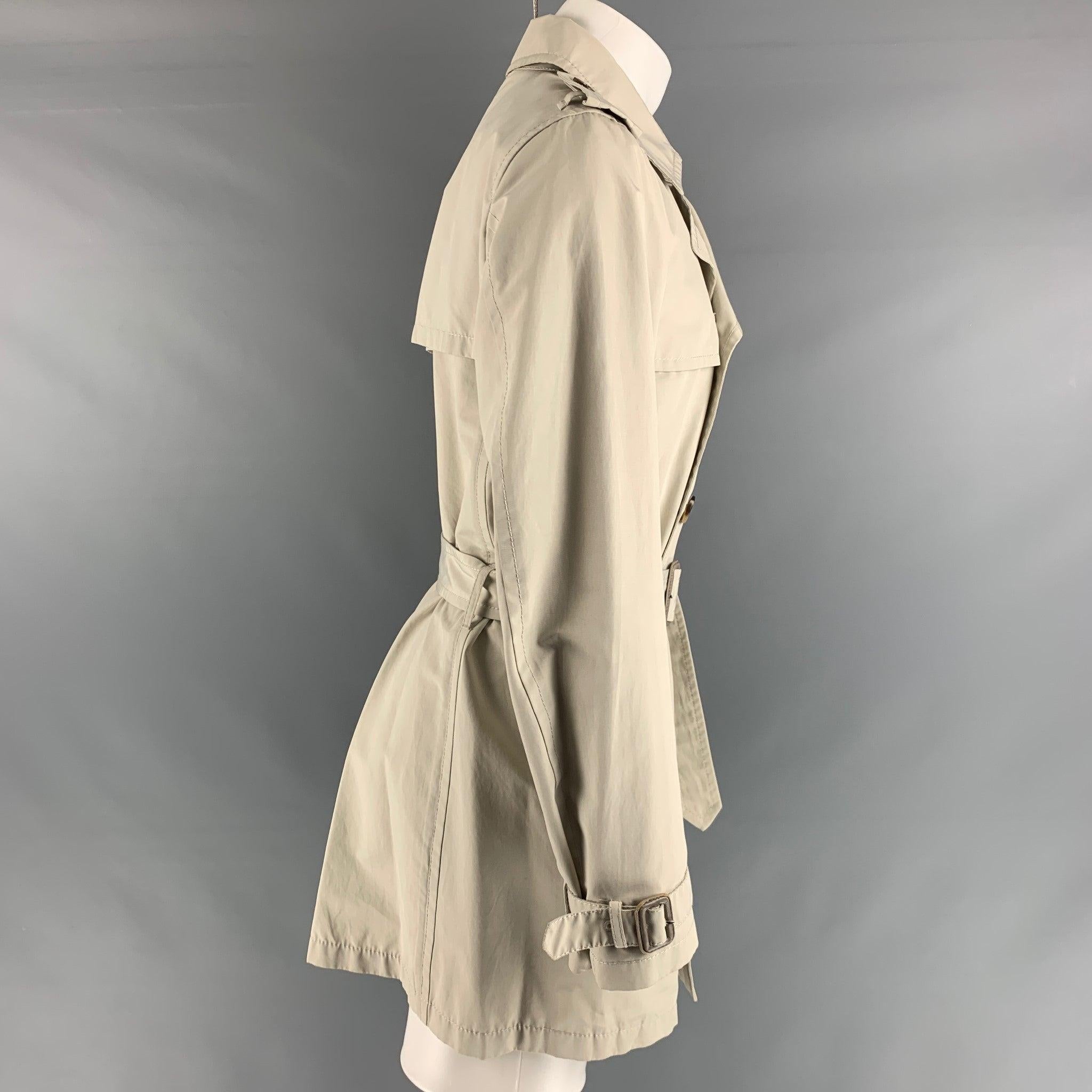 PRADA trench coat comes in a ivory cotton and polyester woven material featuring a belted style, epaulettes, front pockets, and a double breasted closure. Made in Italy.Very Good Pre-Owned Condition. Minor marks, please see pictures. 

Marked:  48
