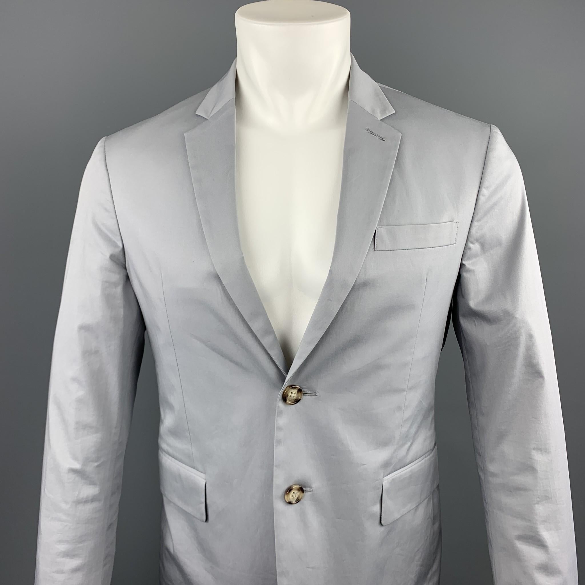 PRADA sport coat comes in a light gray cotton featuring a notch lapel, patch pockets, and a two button closure. 

Excellent Pre-Owned Condition.
Marked: 48

Measurements:

Shoulder: 16.5 in.
Chest: 38 in.
Sleeve: 26 in.
Length: 28 in.  