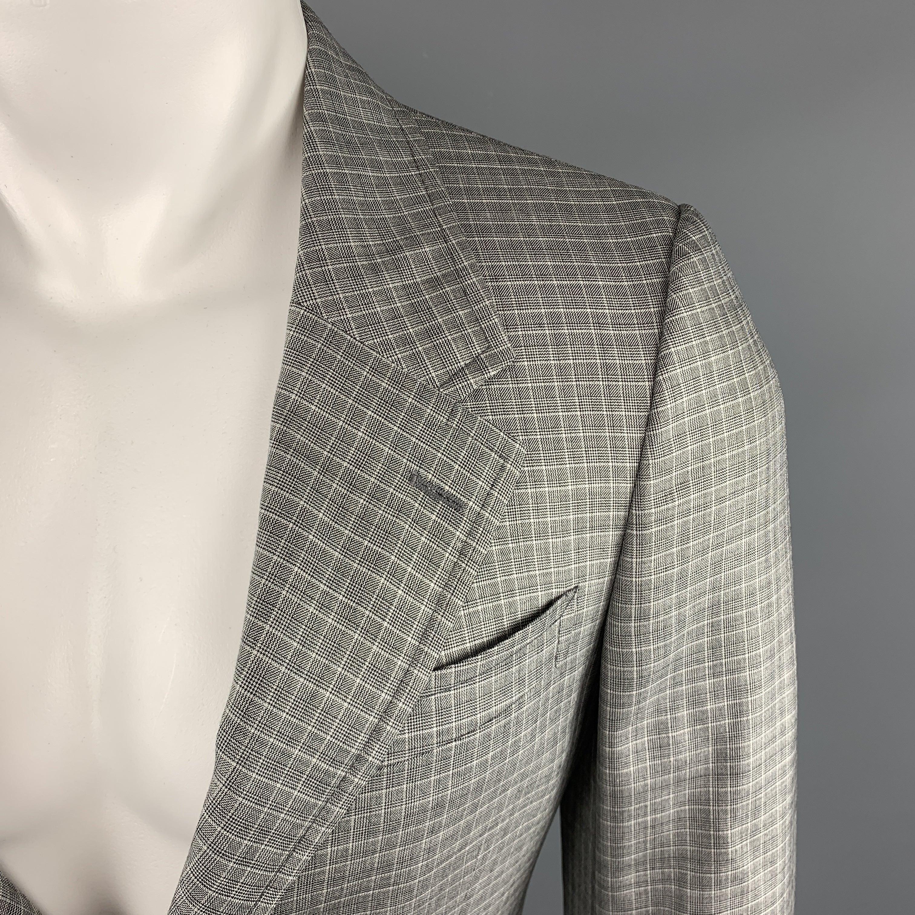 PRADA Sport Coat comes in a grey tone in a plaid wool / silk material, with a notch lapel, slit and flap pockets, two buttons at closure, single breasted, buttoned cuffs, a double vent at back, unlined. Made in Italy. Excellent Pre-Owned Condition.
