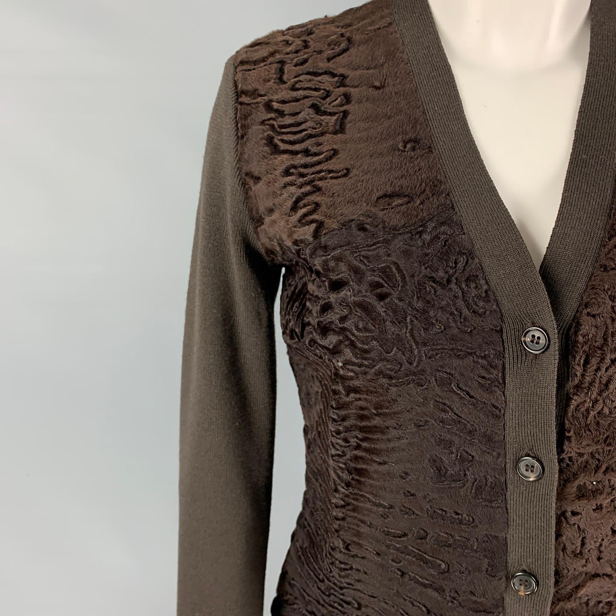 PRADA cardigan comes in a brown knitted wool featuring a lamb fur panel design and a buttoned closure. Made in Italy. 

Excellent Pre-Owned Condition.
Marked: 40

Measurements:

Shoulder: 15 in.
Bust: 32 in.
Sleeve: 23 in.
Length: 21 in.