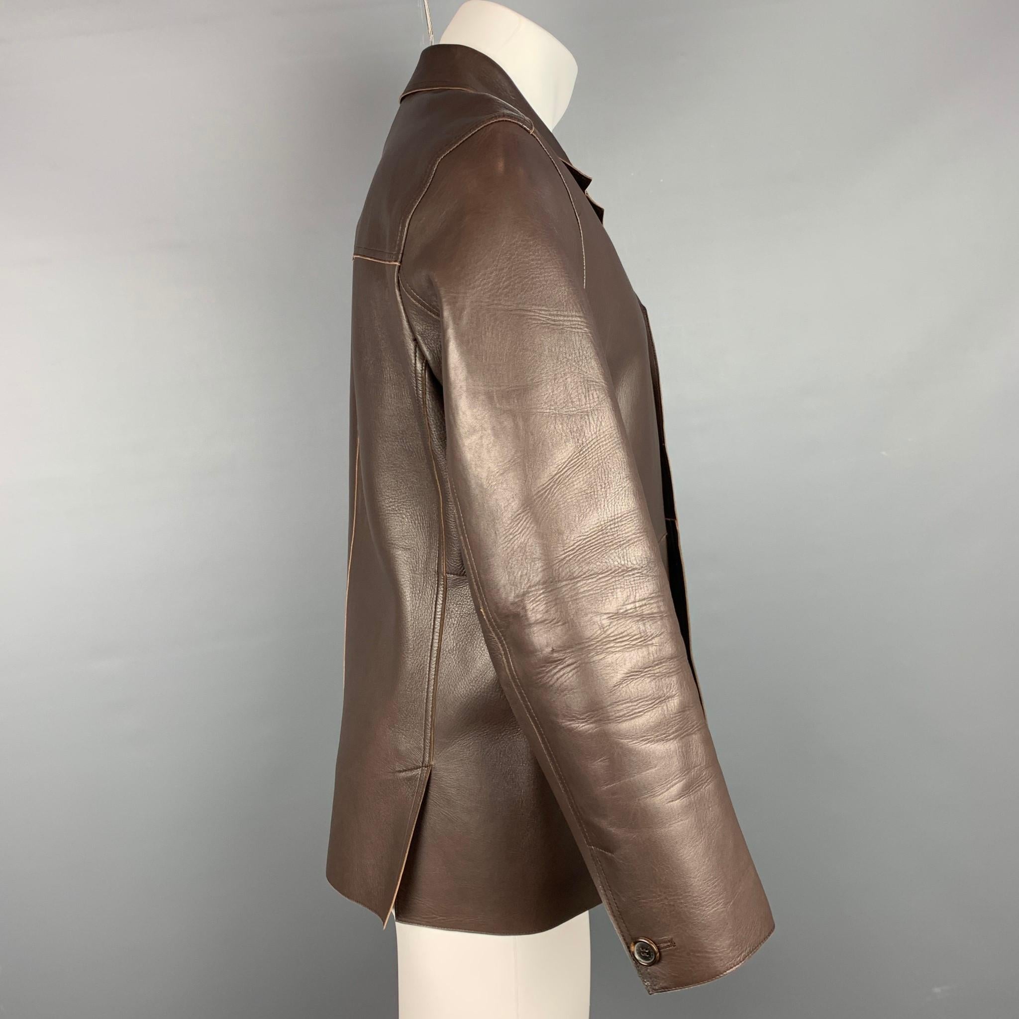 PRADA jacket comes in a brown leather with no liner featuring a notch lapel, slit pockets, and a buttoned closure. Made in Italy.

Very Good Pre-Owned Condition.
Marked: 50

Measurements:

Shoulder: 18 in.
Chest: 42 in.
Sleeve: 24 in.
Length: 28.5