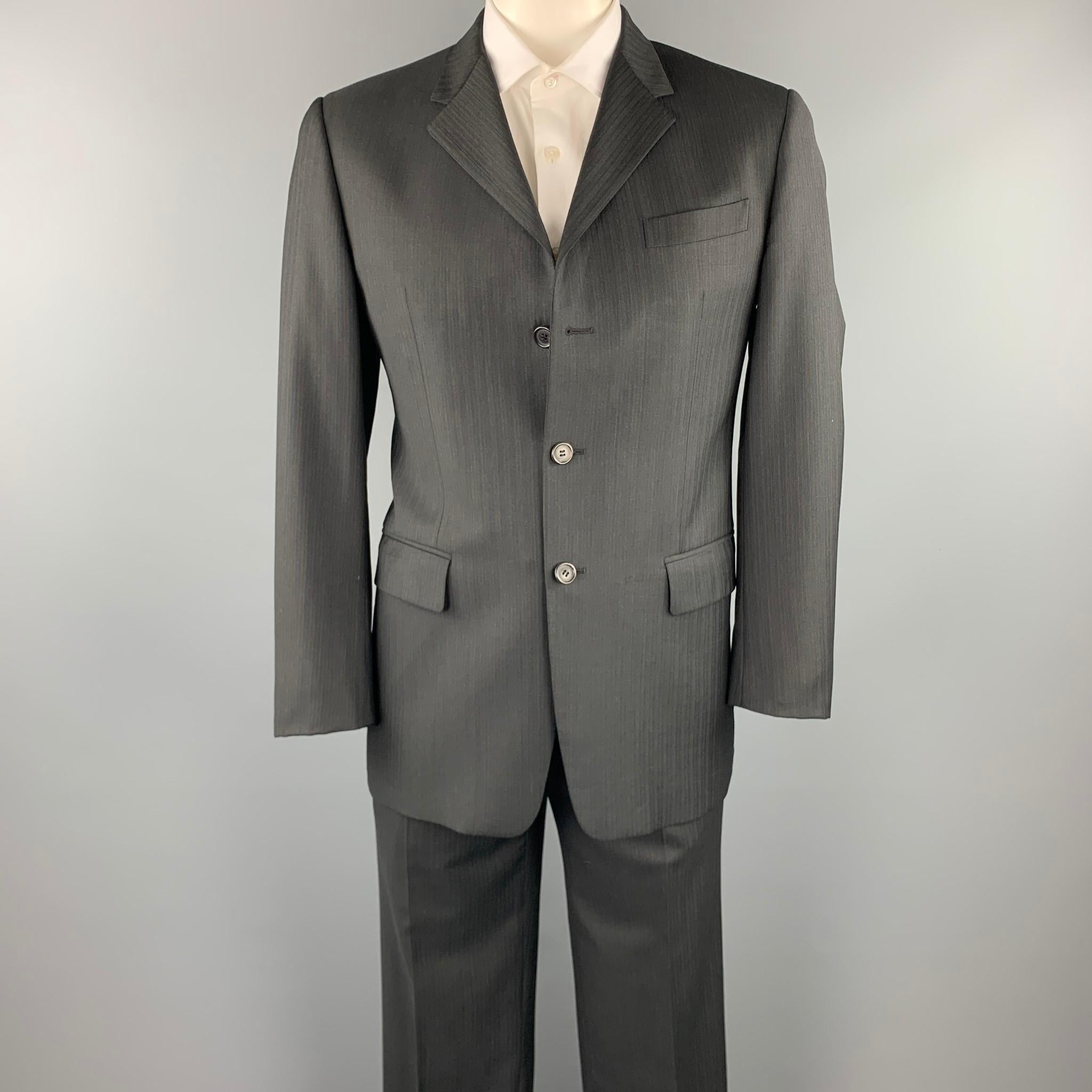 PRADA suit comes in a charcoal stripe virgin wool with a full liner and includes a single breasted, three button sport coat with a notch lapel and matching flat front trousers. Made in Italy.

Excellent Pre-Owned Condition.
Marked: IT 50