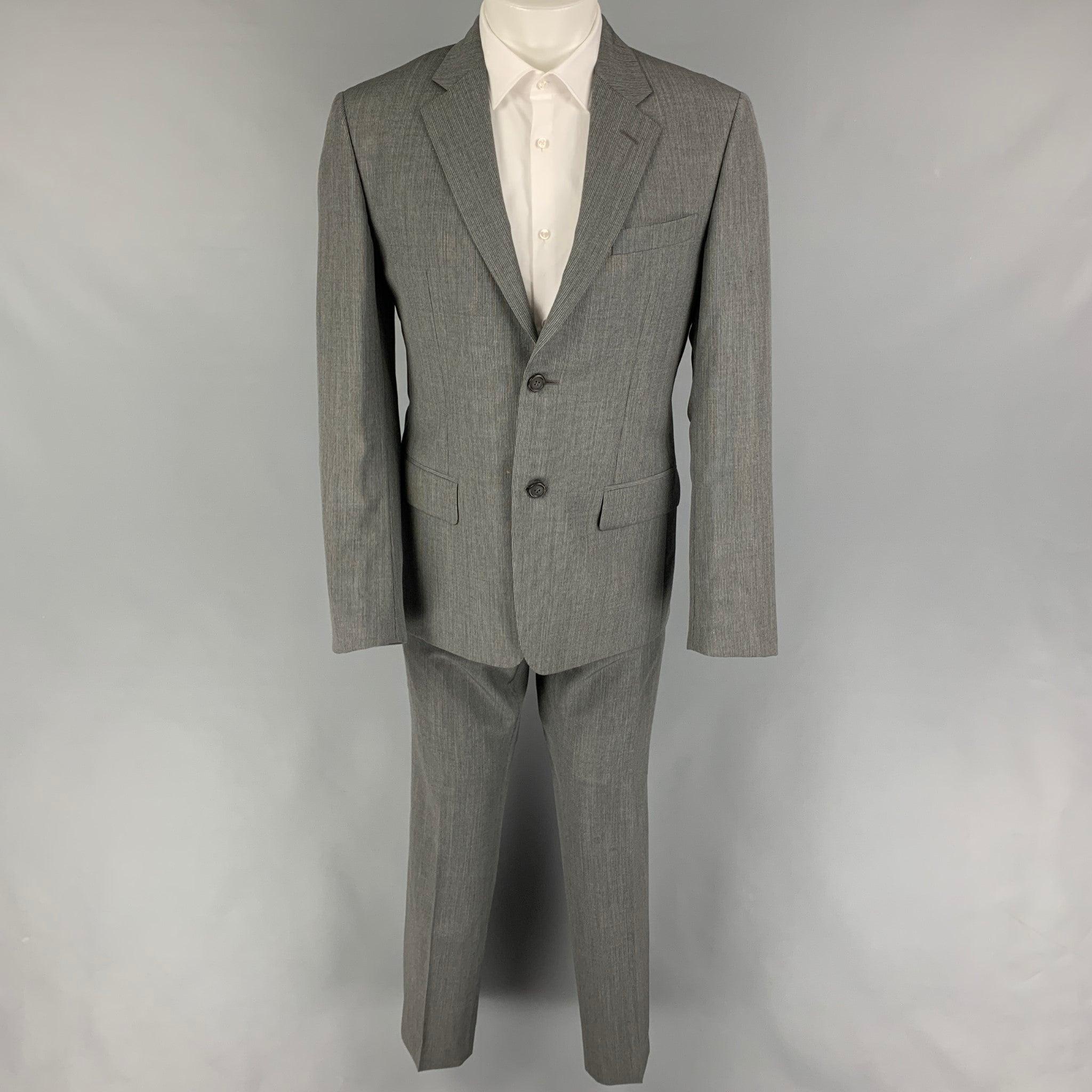 PRADA
suit comes in grey & silk pinstripe virgin wool and includes a single breasted, double button sport coat with a notch lapel and matching flat front trousers. Made in Italy. Very Good Pre-Owned Condition. 

Marked:   50 R  

Measurements: 
 