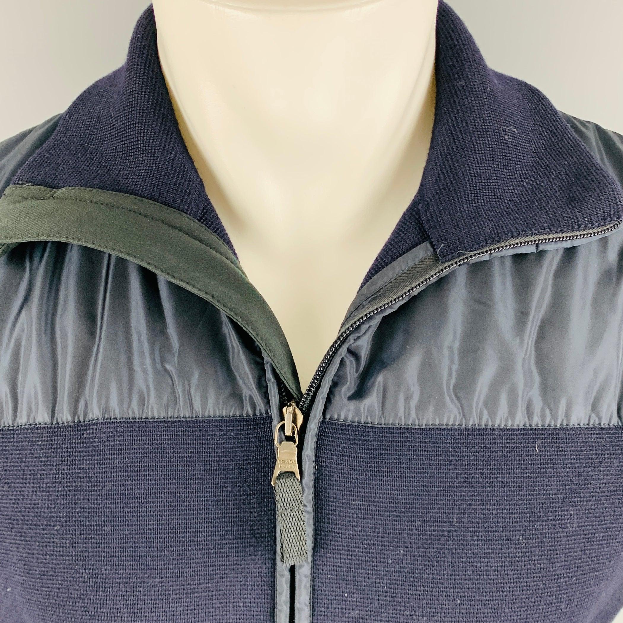 PRADA jacket
in a navy wool fabric with nylon trim, featuring a waffle knit style, blouson sleeves, and zip up closure. Made in Romania.Very Good Pre-Owned Condition. Minor mark on left sleeve, and small tear on back. 

Marked:   50 

Measurements: