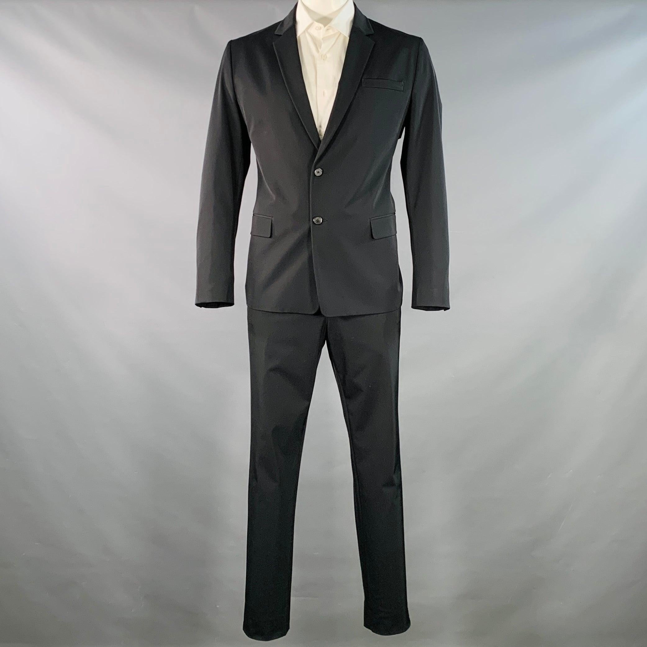 PRADA
Il completo è in twill di poliestere nero elasticizzato con fodera integrale e comprende un cappotto sportivo monopetto a due bottoni con revers a lancia e pantaloni piatti abbinati. Made in Italy.Ottime condizioni di usato. 

Contrassegnato: 