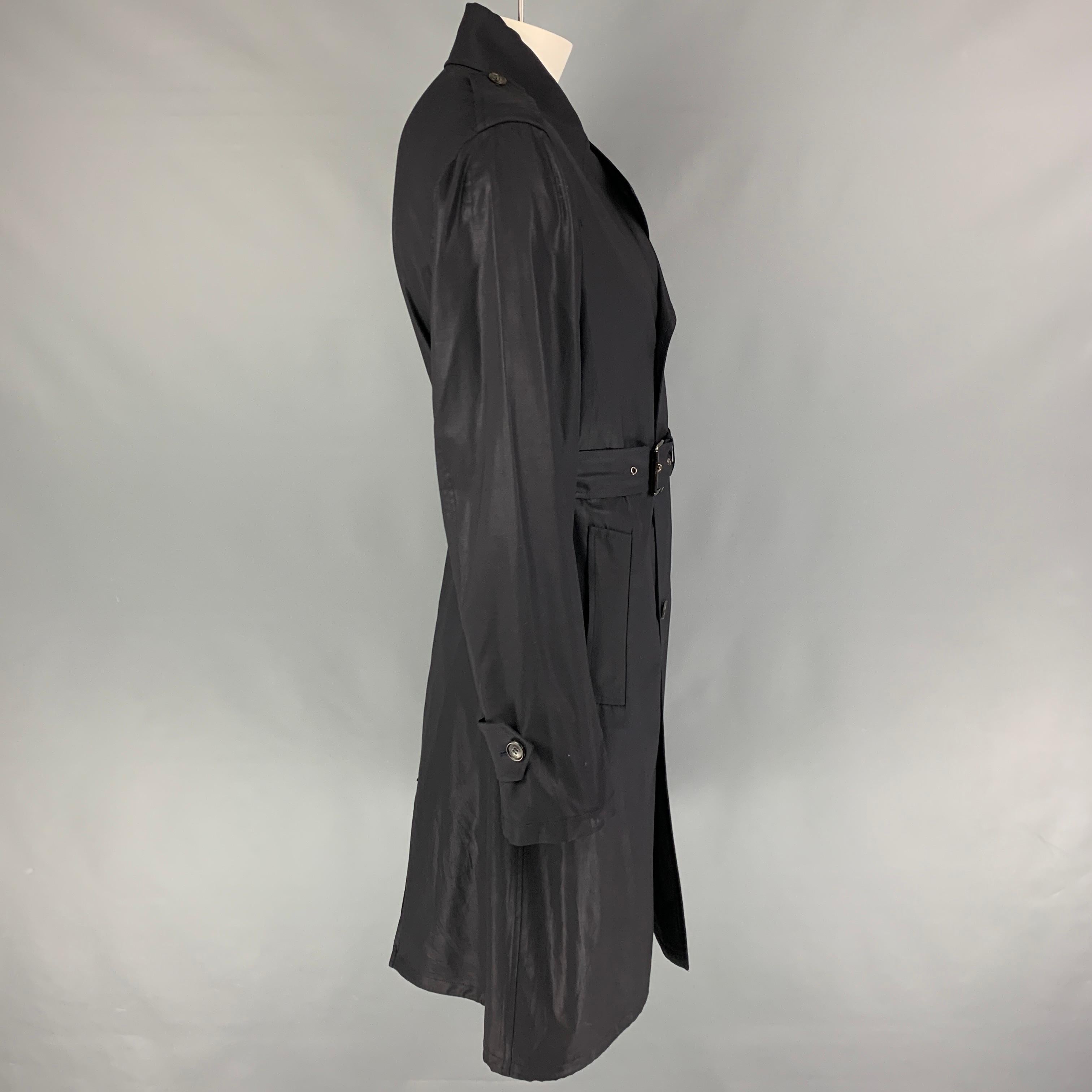 PRADA trench coat comes in a navy material with a full liner featuring a belted style, notch lapel, epaulettes, slit pockets, and a double breasted closure. Made in Italy. 

Very Good Pre-Owned Condition. Fabric tag removed.
Marked: Size tag