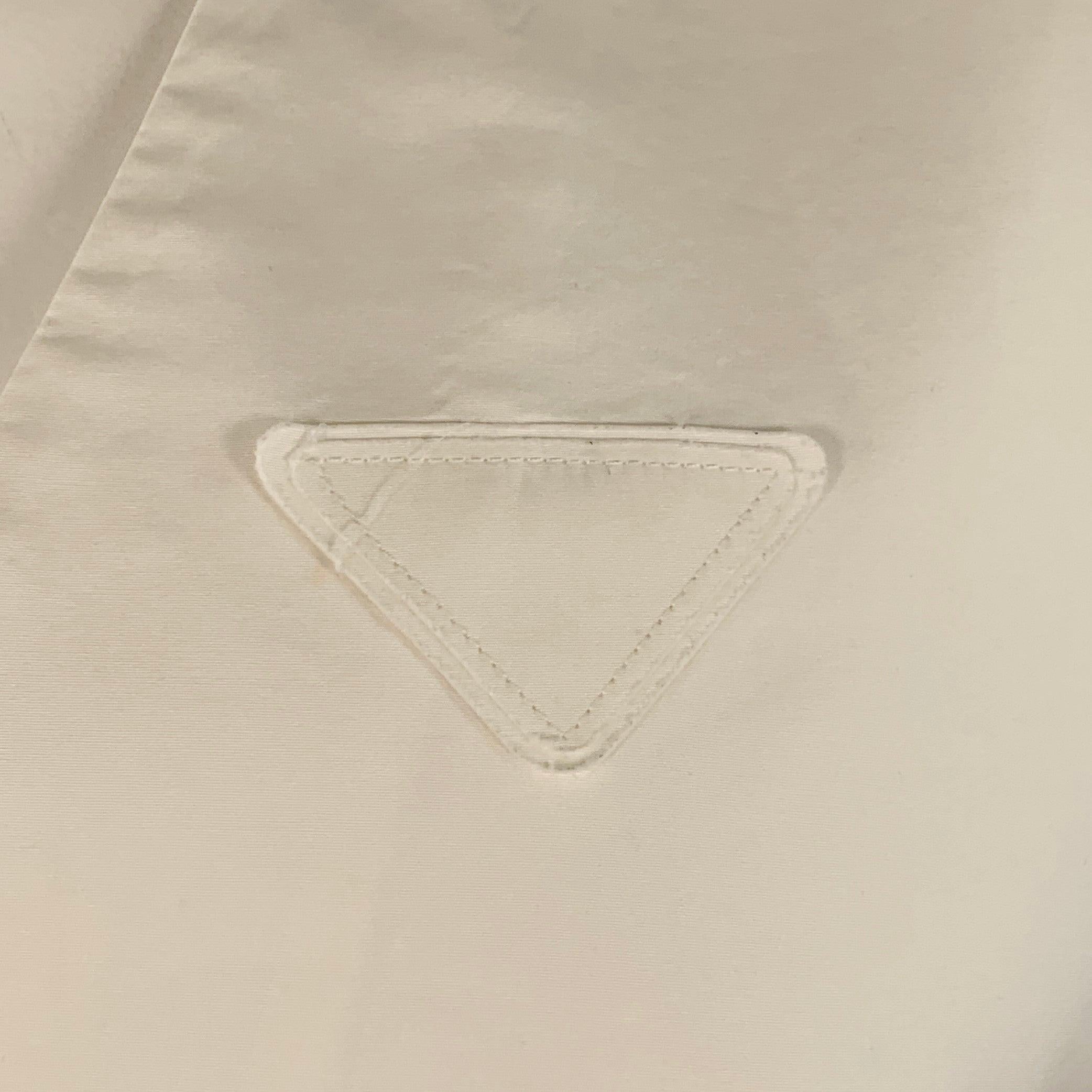 PRADA vest
in a white cotton woven fabric featuring tonal triangle logo patch, back cinch, and hidden button closure. Note: this garment has been professionally altered. Please double check measurements. Made in Italy.Very Good Pre-Owned Condition.