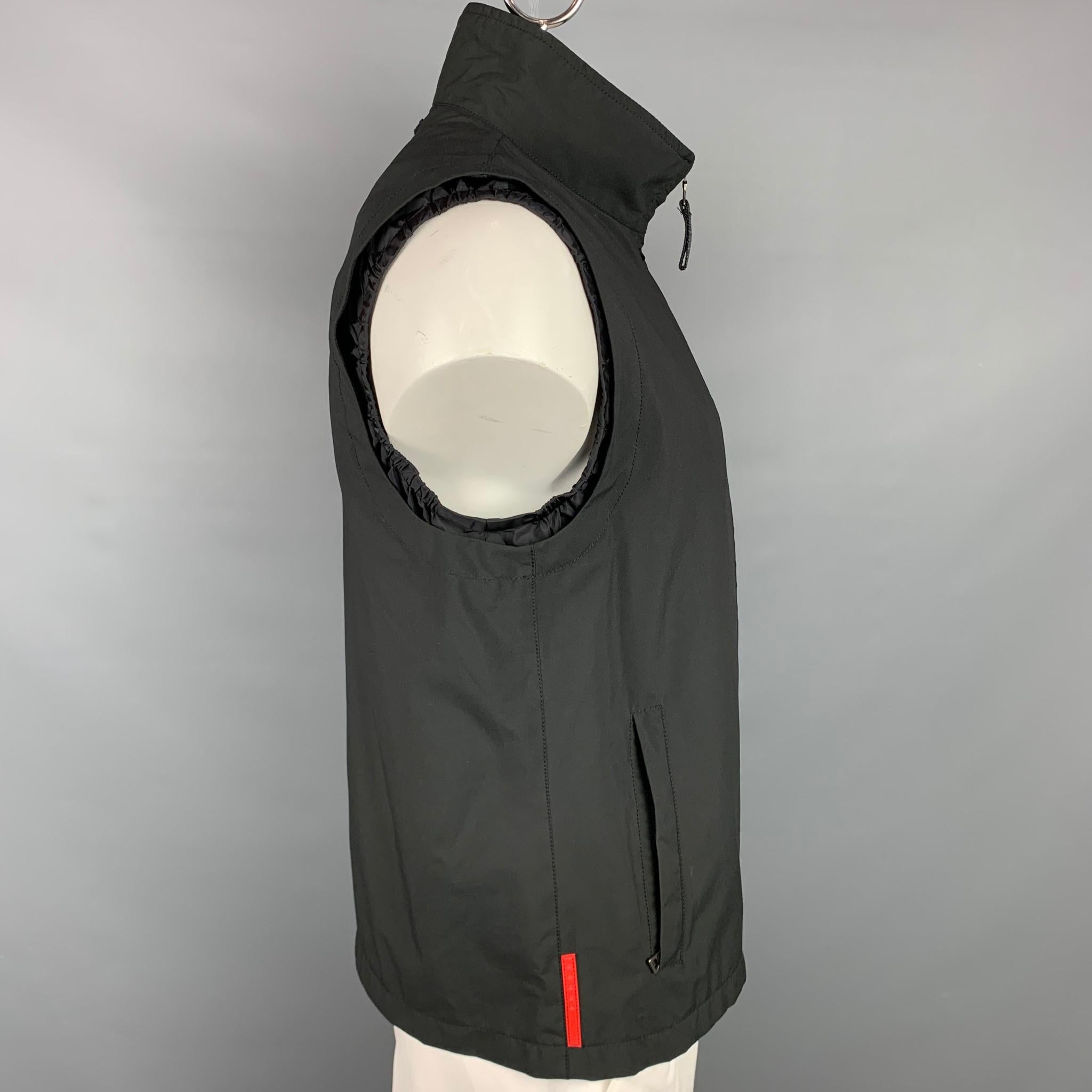 PRADA vest comes in a black polyester featuring a double layer design, zipper pockets, high collar, and a full zip up closure.

Good Pre-Owned Condition.
Marked: 54

Measurements:

Shoulder: 17.5 in.
Chest: 44 in.
Length: 27 in. 

SKU: