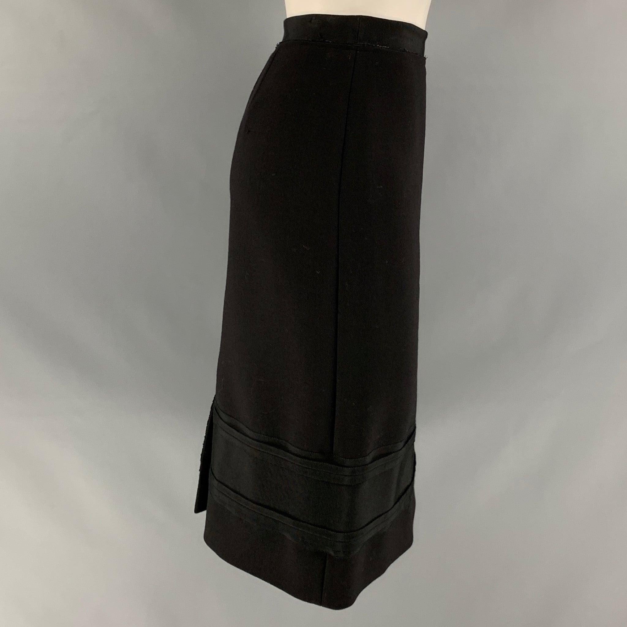 PRADA knee length skirt comes in a black wool mixed materials featuring a pencil style, back zipper closure, and grosgrain ribbon hem details. Made in Italy.Very Good Pre-Owned Condition. 

Marked:   42 

Measurements: 
  Waist: 30 inches  Hip: 40