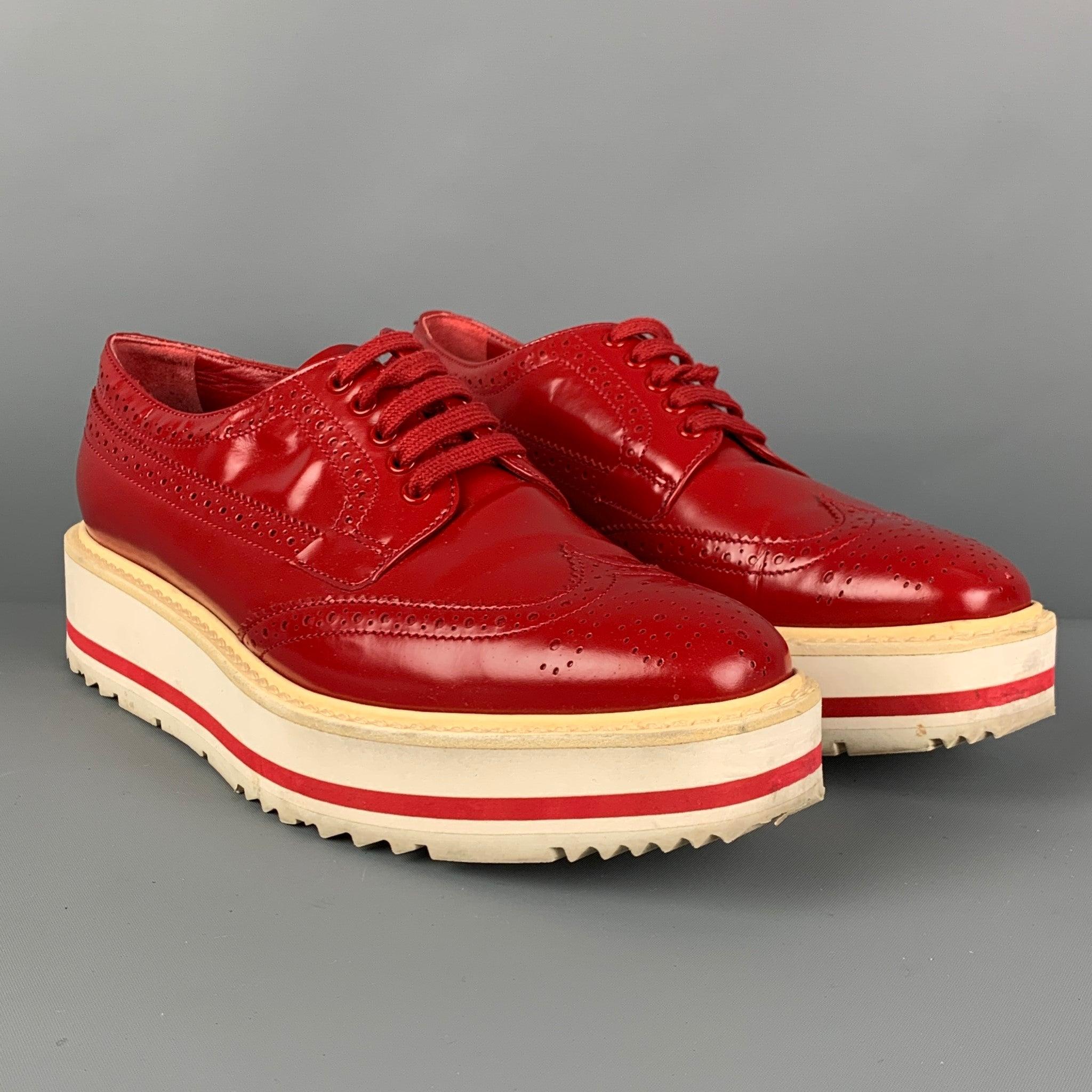 Les chaussures PRADA sont en cuir perforé rouge et blanc et présentent un style à bouts d'aile, une semelle compensée en caoutchouc et une fermeture à lacets.
Très bien
Etat d'occasion. 

Marqué :   36Semelle d'usure : 10.5 x 3.5 pouces 
  
  
