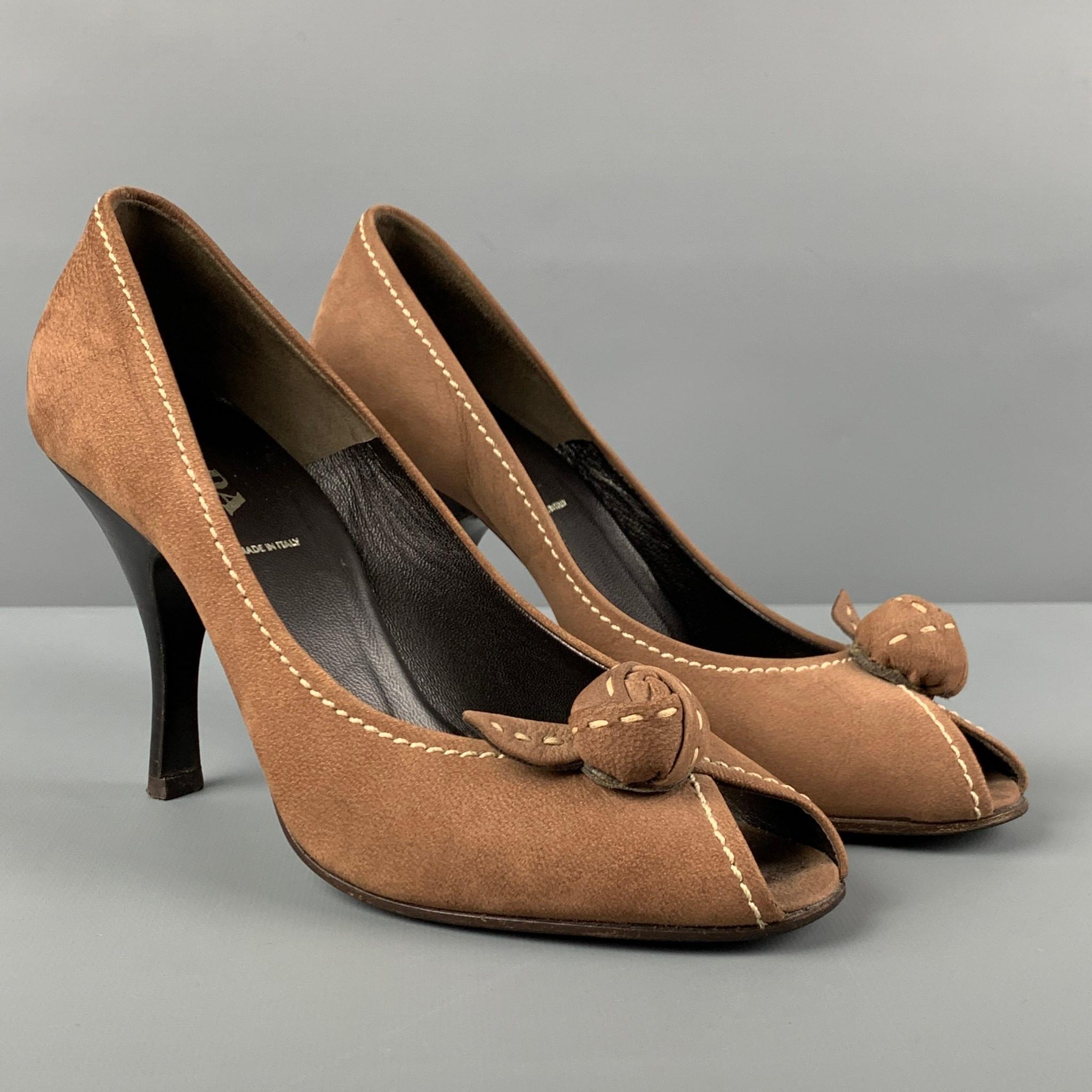 PRADA pumps comes in a brown suede featuring a knot detail, top stitching, open toe, and a stiletto heel. Made in Italy. 

Very Good Pre-Owned Condition.
Marked: 36.5

Measurements:

Heel: 3.75 in. 