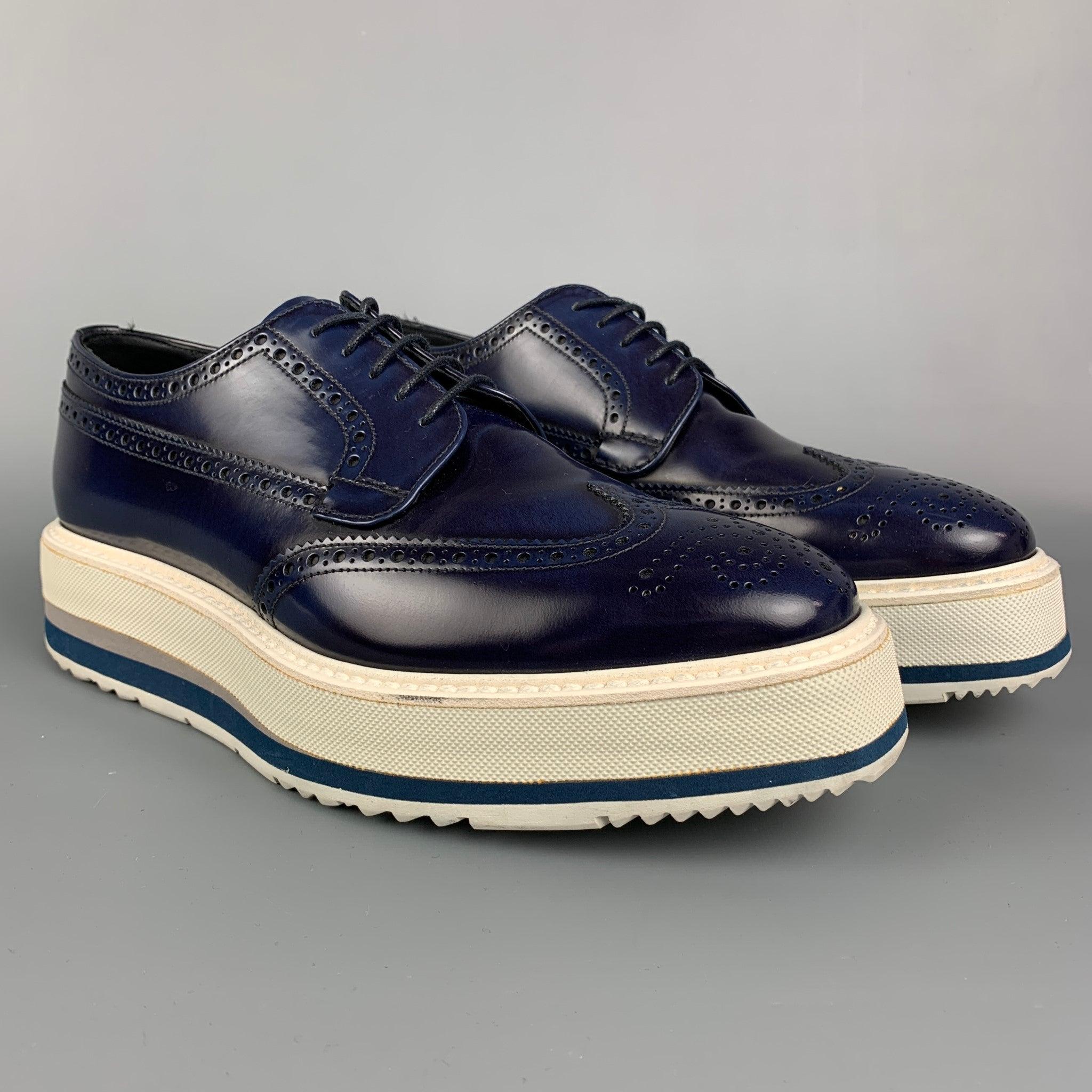 PRADA shoes comes in a navy & white perforated leather featuring a wingtip style, platform, rubber sole, and a lace up closure. Made in Italy.
 Very Good
 Pre-Owned Condition. 
 

 Marked:  2EG015 5.5Outsole: 11.5 inches x 4 inches 
 

  
  
  
 Sui