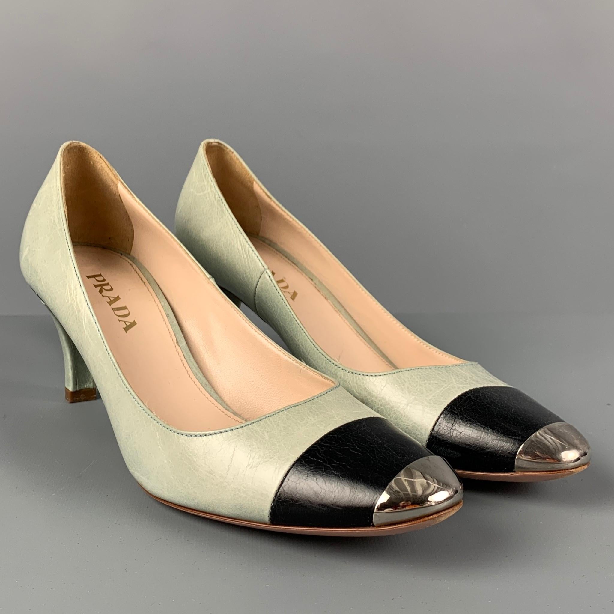 PRADA pumps comes in a mint leather featuring a black cap toe, silver tone detail, and a kitten heel. Made in Italy.

Very Good Pre-Owned Condition.
Marked: 37

Measurements:

Heel: 2.5 in.
 
