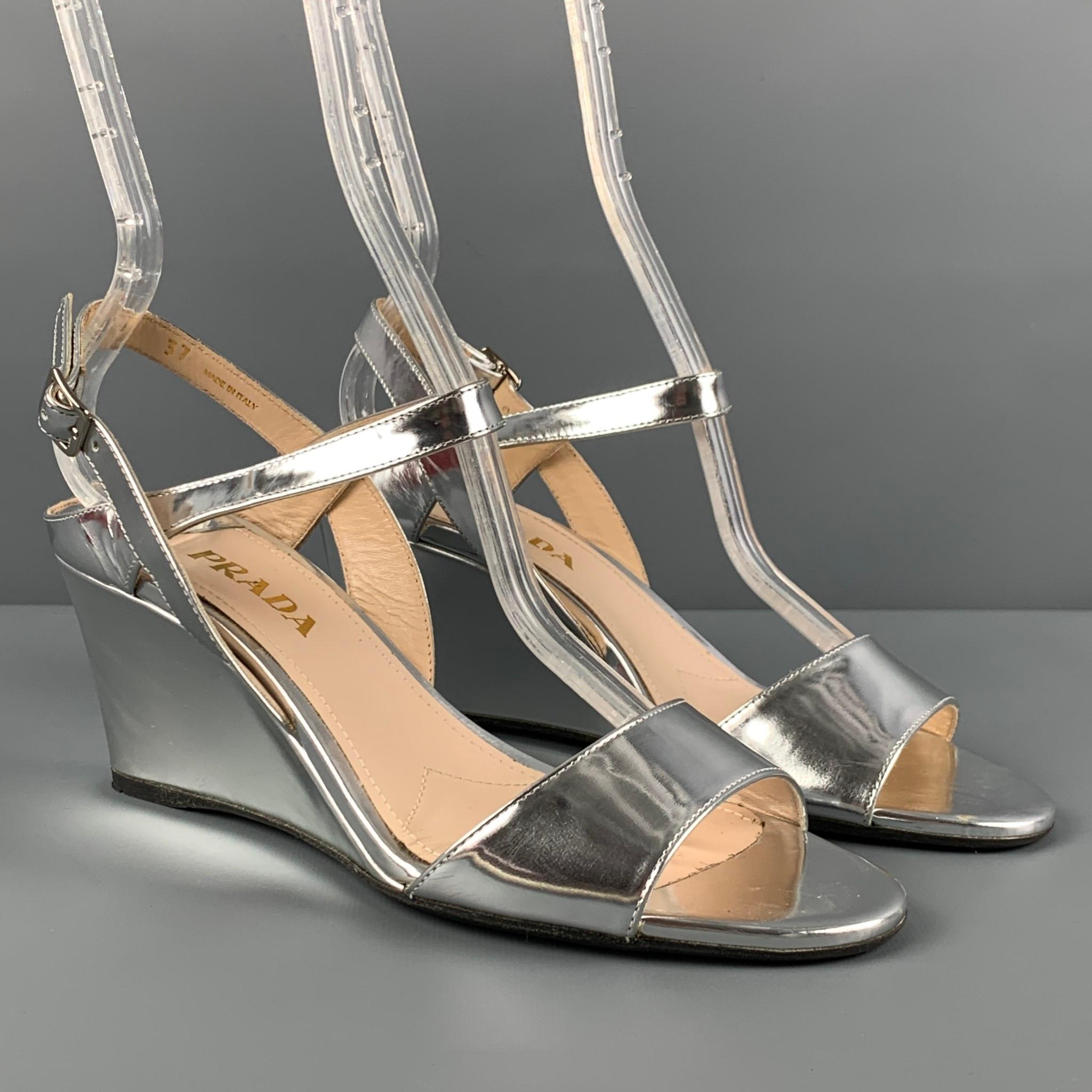 PRADA wedges comes in a silver metallic leather featuring a slingback style and a wedge heel. Includes box. Made in Italy. 

Very Good Pre-Owned Condition.
Marked: 37

Measurements:

Heel: 2.75 in. 