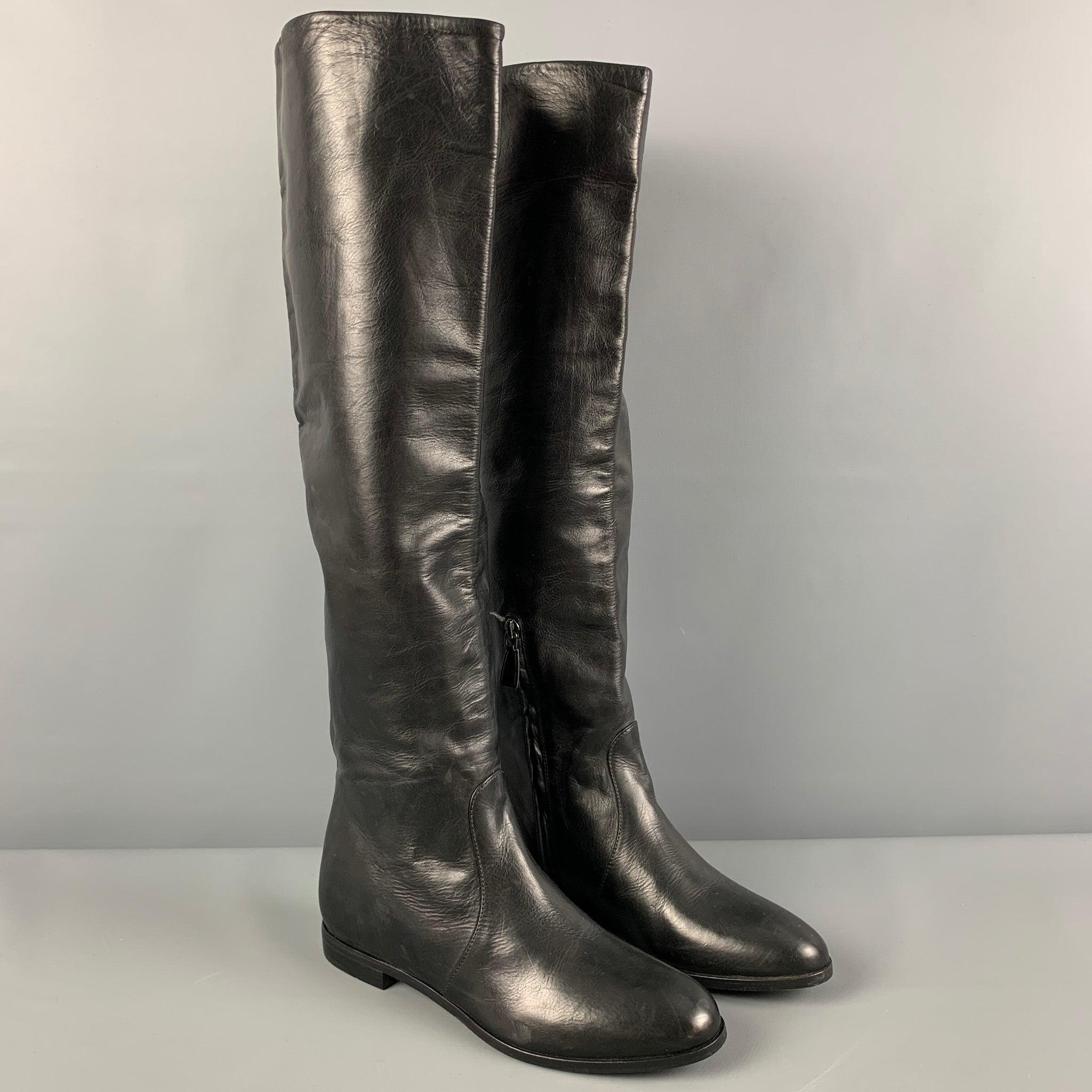 PRADA boots comes in a black leather featuring a flat heel and aside zipper closure. Made in Italy.Very Good
Pre-Owned Condition. 

Marked:   37.5 

Measurements: 
  Length: 10 inches Width: 3.5 inches Height: 20 inches 
  
  
 
Reference:
