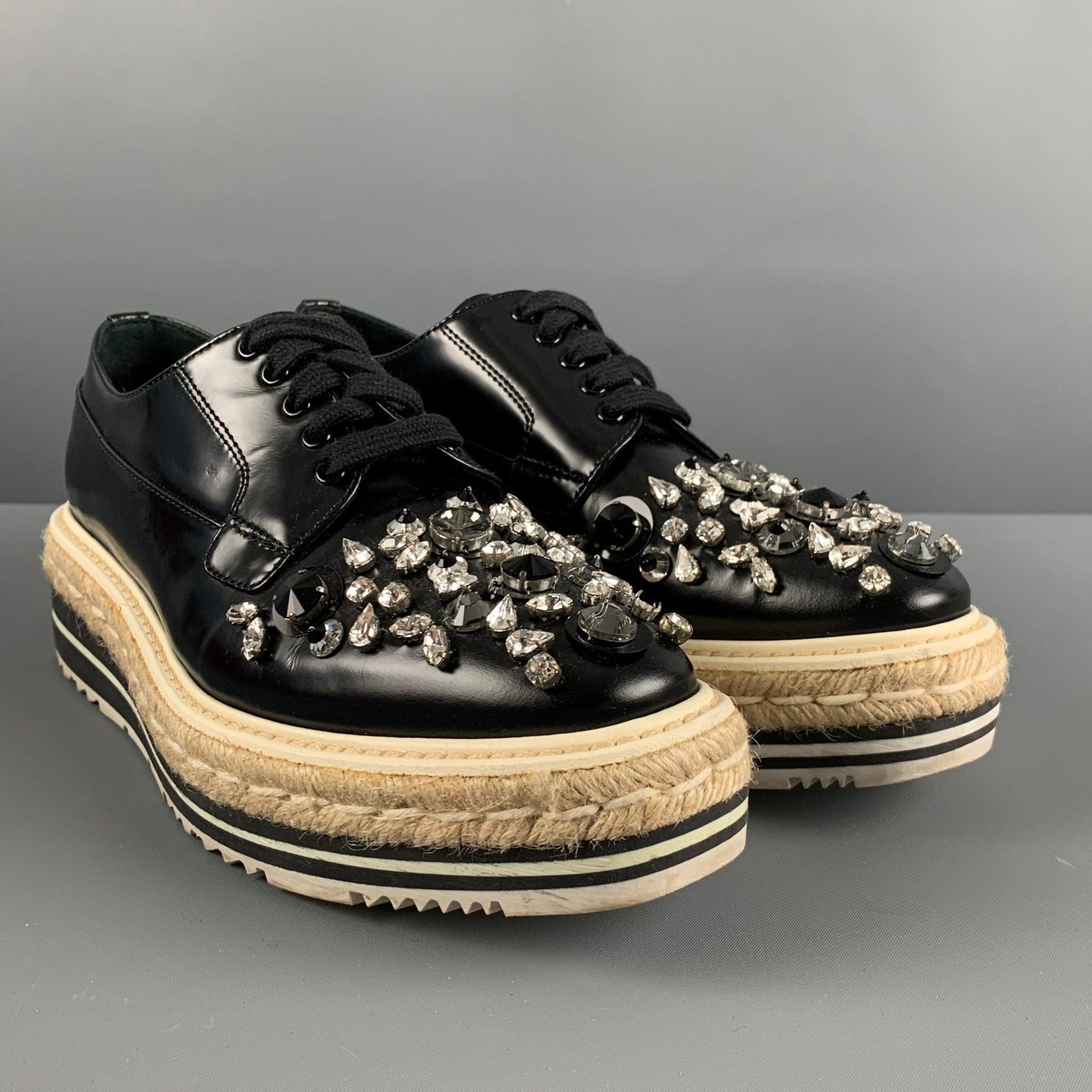 PRADA shoes comes in a black leather featuring rhinestone details, rubber sole, woven espadrilles detail, and a lace up closure. Made in Italy. Comes with The box.Very Good Pre- Owned Closure. 

Marked:   37.5Outsole: 10.75 inches  x 4 inches  
  
 