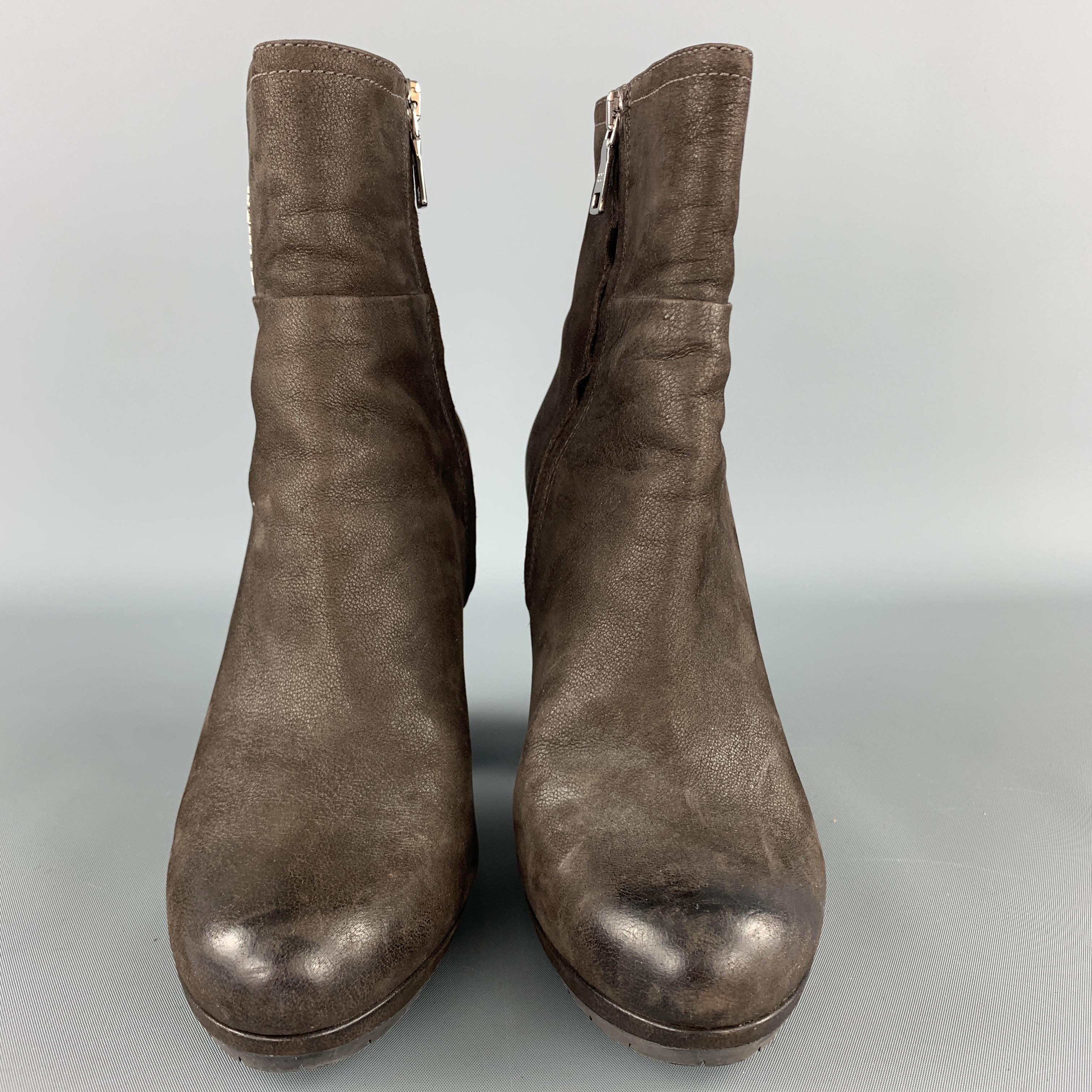 PRADA ankle booties come in textured brown leather with a silver tone logo shaft and chunky heeled sole. 

Very Good Pre-Owned Condition.
Marked: IT 37.5

Heel: 4 in.
Length: 5 in.