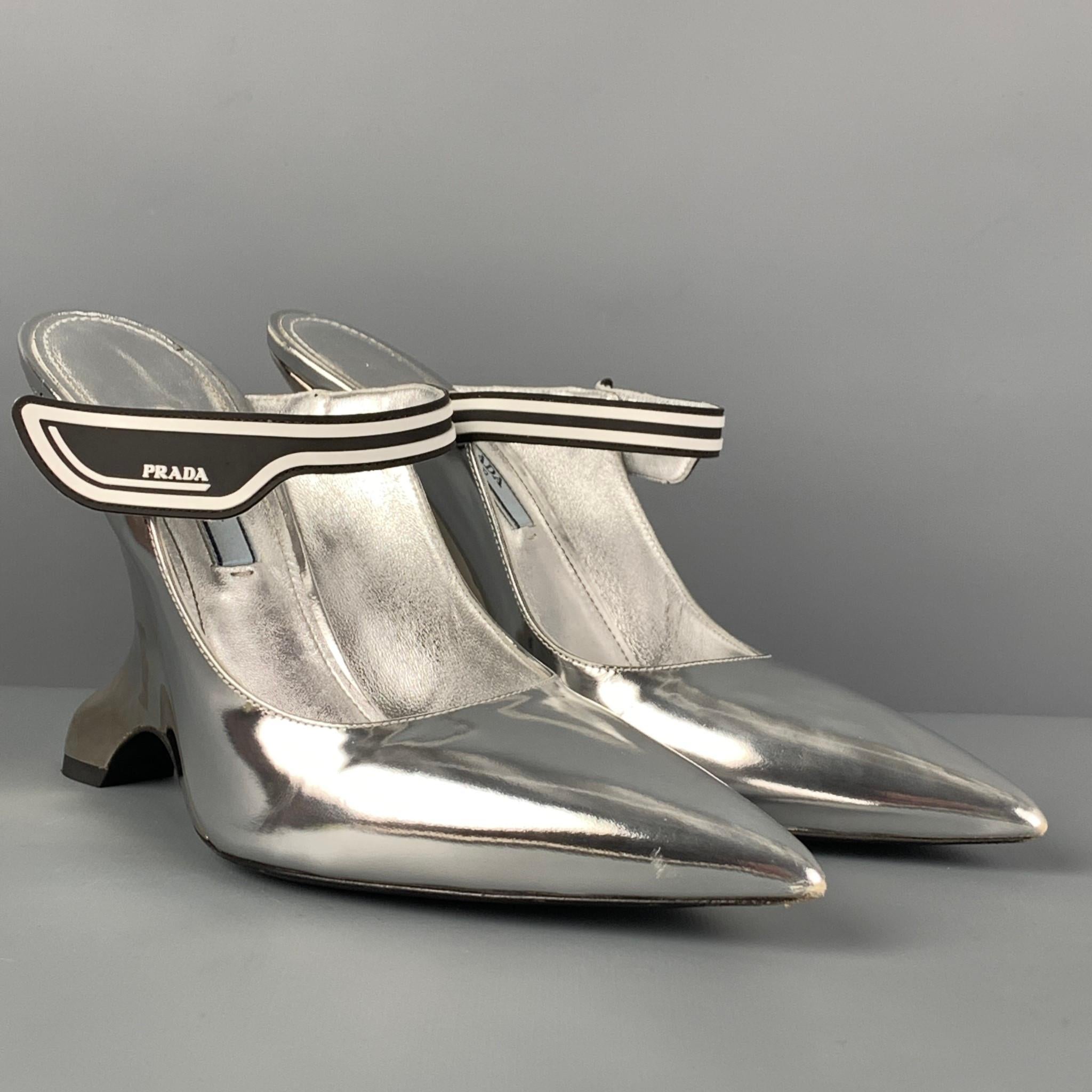 PRADA pumps comes in a silver metallic mirror-finish leather, pointed toe, contrast logo rubber strap, and a sculptural heel. Made in Italy.

Very Good Pre-Owned Condition.
Marked: 37.5
Original Retail Price: $950.00

Measurements:

Heel: 5 in. 