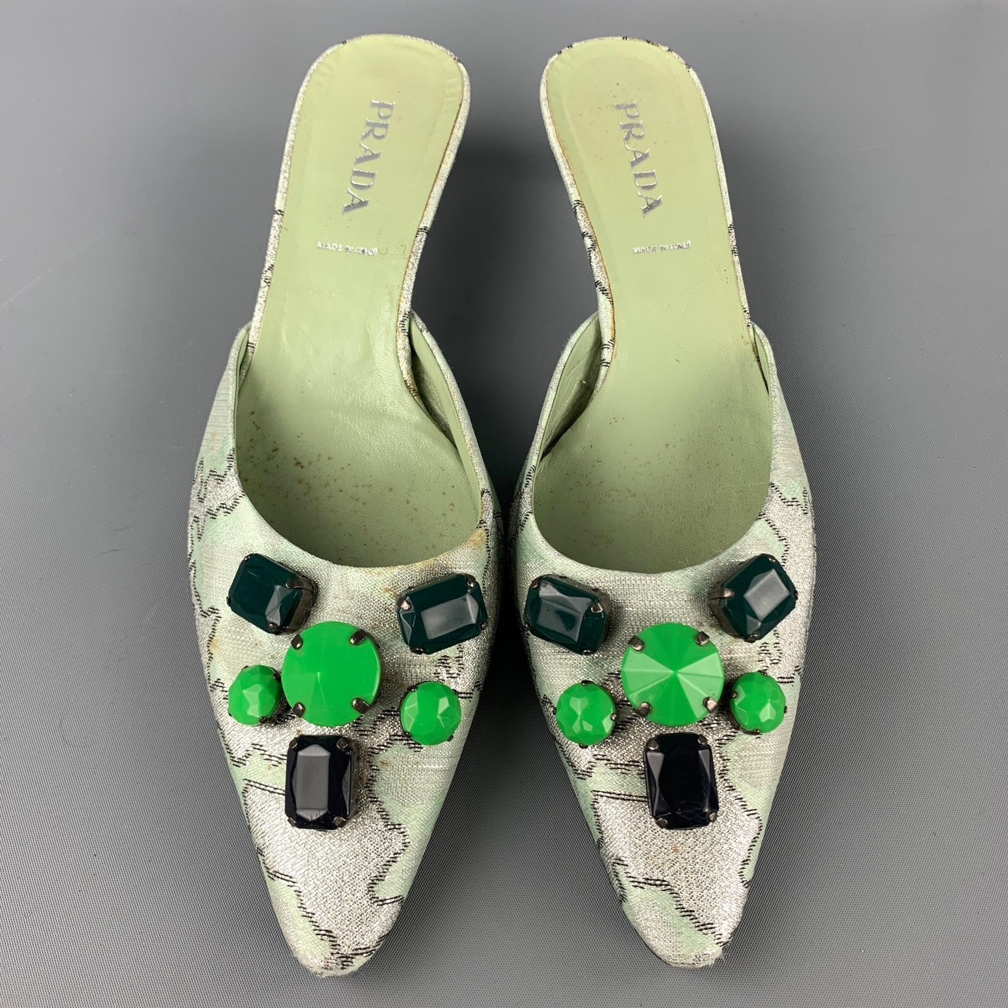 PRADA pumps comes in a green print silk with front embellishment details featuring a mule style, pointed toe, and a kitten heel. Moderate wear. Made in Italy.Good Pre-Owned Condition. 

Marked:   EU 38.5 

Measurements: 
  Heel: 2 inches 
  
  

