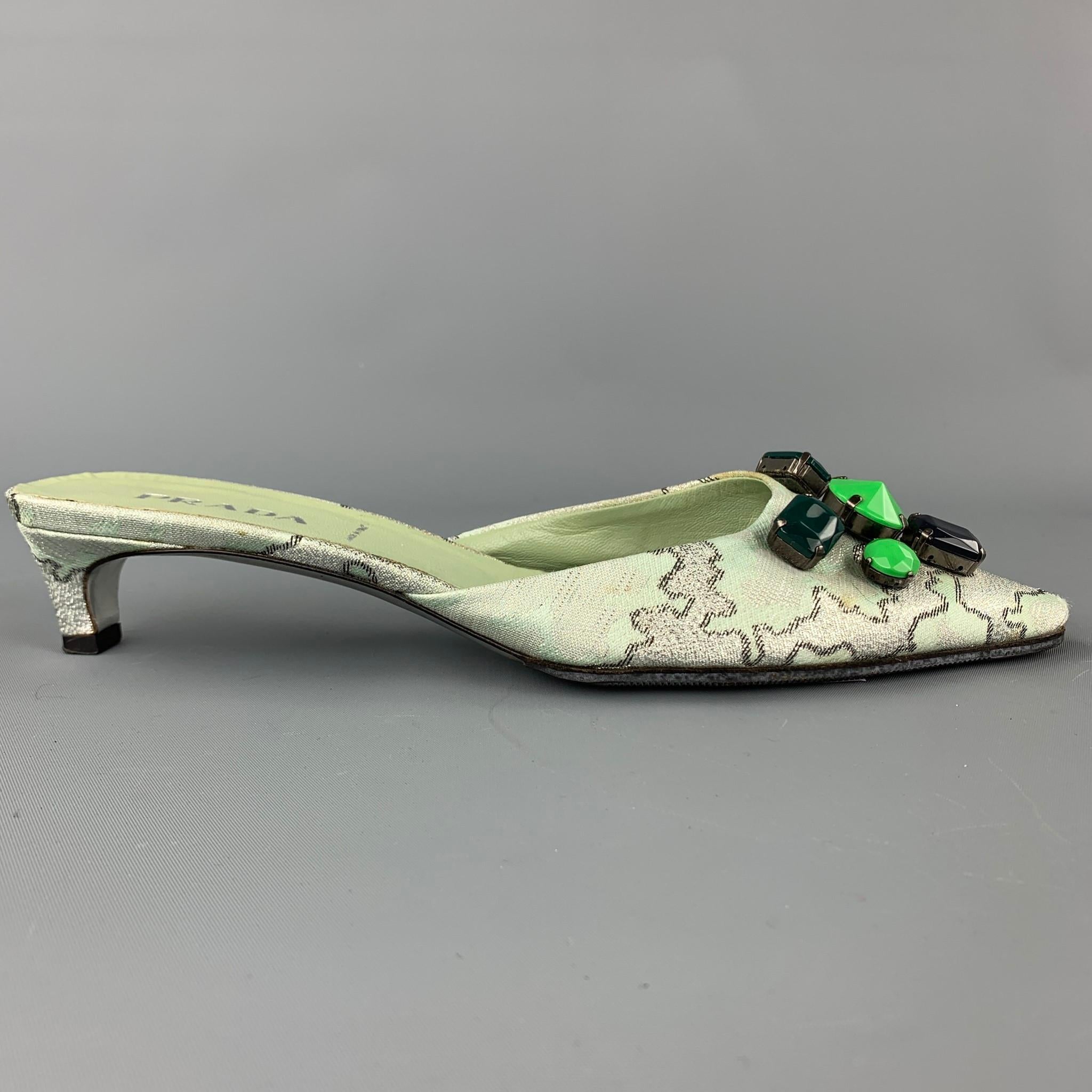 PRADA pumps comes in a green print silk with front embellishment details featuring a mule style, pointed toe, and a kitten heel. Moderate wear. Made in Italy.

Good Pre-Owned Condition.
Marked: EU 38.5

Measurements:

Heel: 2 in. 