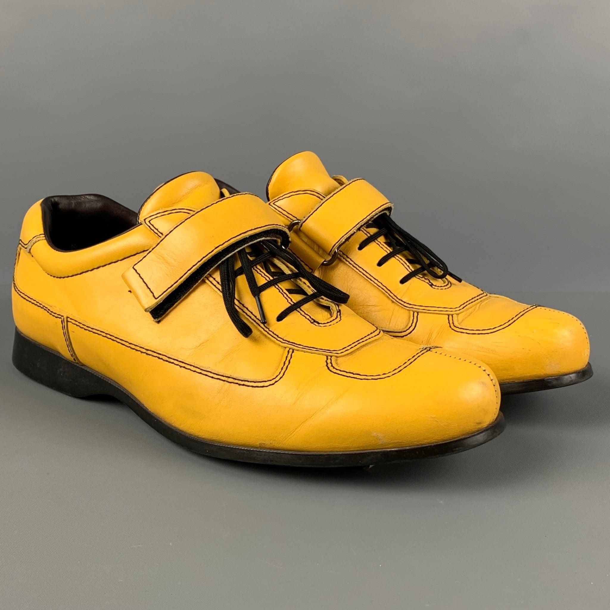PRADA shoes comes in a yellow leather featuring a split toe, contrast stitching, front strap detail, rubber sole, and a lace up closure. Made in Italy.
 Good
 Pre-Owned Condition. Moderate wear. As-Is.  
 

 Marked:  8 4 E0868 7.5Outsole: 11.5