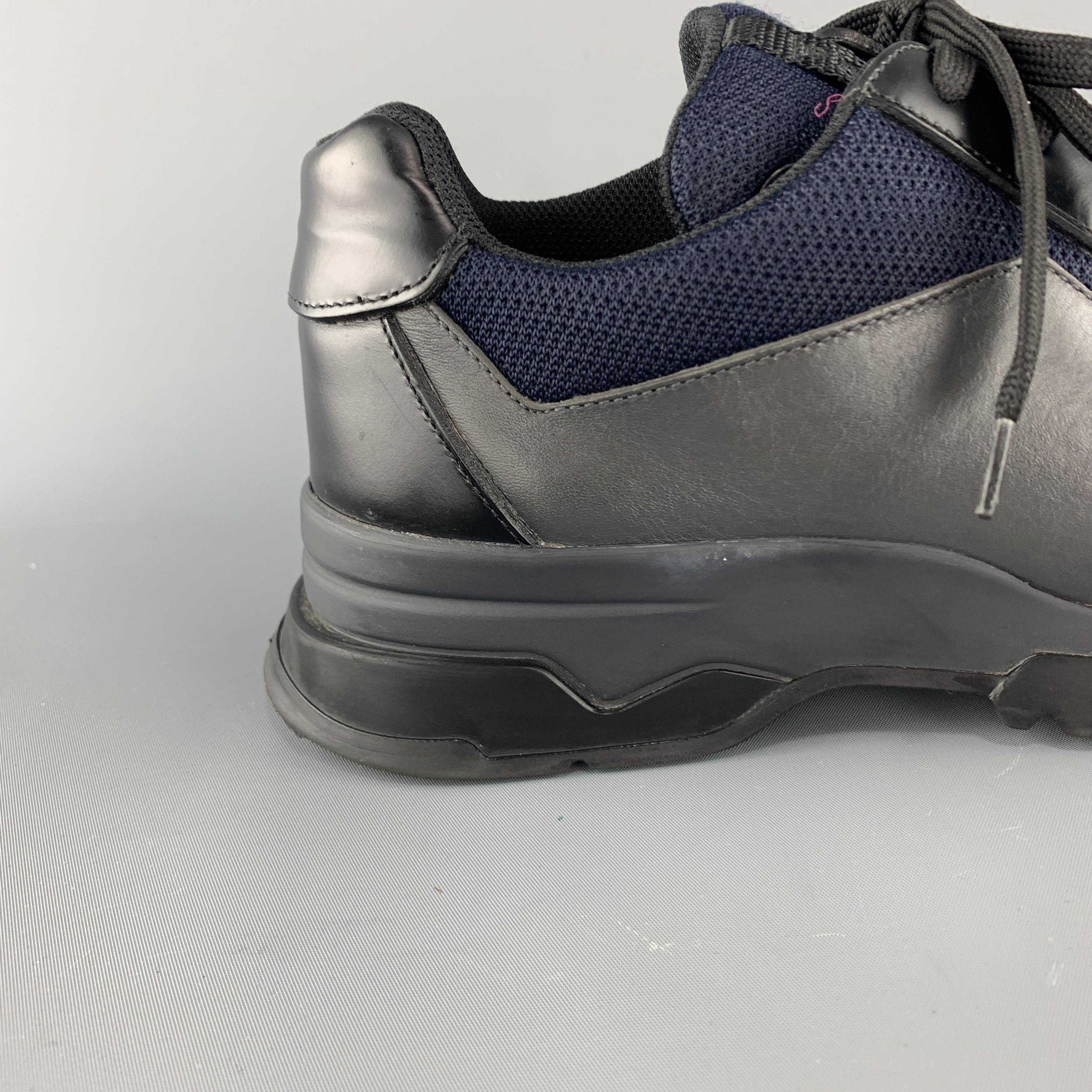 PRADA dress sneaker comes in gray and black leather with navy blue mesh panels, lace up front, and extended rubber sole with toe cap. Wear throughout. Made in Italy.

Very Good Pre-Owned Condition.
Marked: UK 8

Outsole: 12.5 x 4.5 in.
